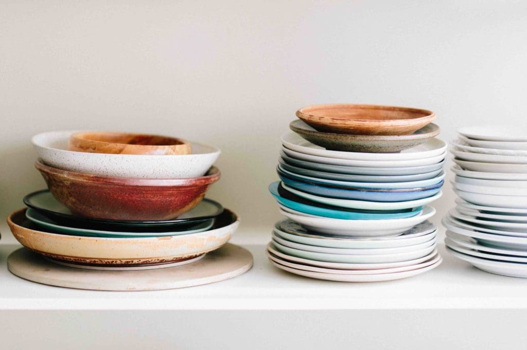 Assortment of rustic plates and bowls stacked on top of each other