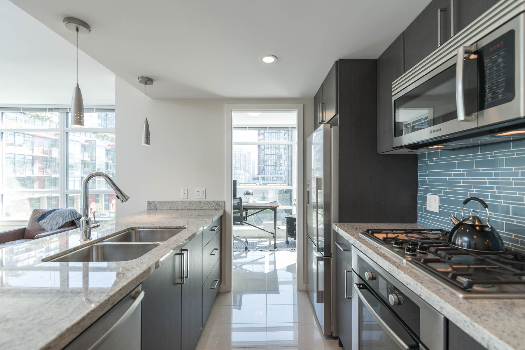 Kitchen with stainless steel appliances inside Olympic Village rental condo.