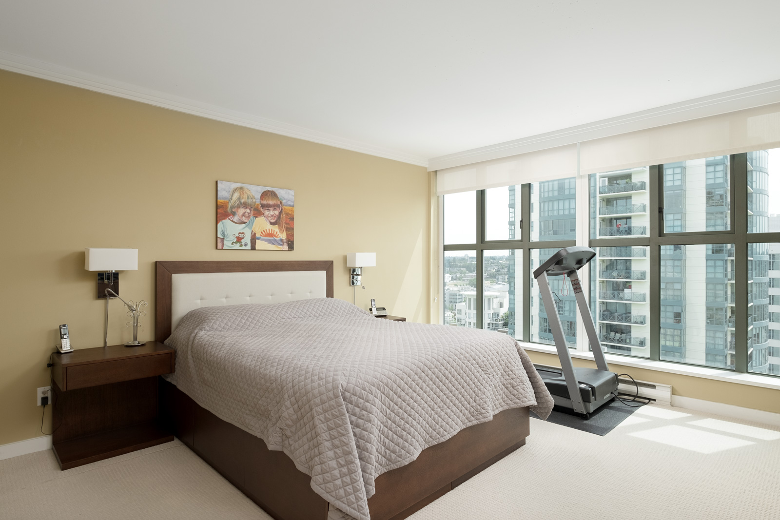 Bedroom with elliptical inside Vancouver rental overlooking city.