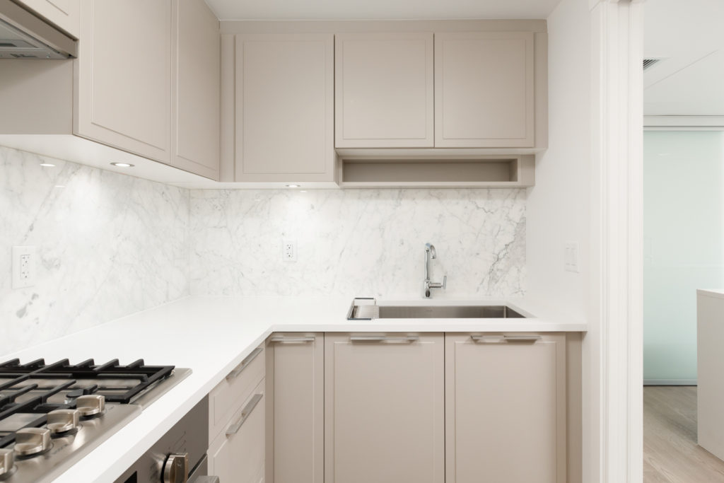 Kitchen area with beige cabinetry inside Vancouver townhome located in the Marpole community.