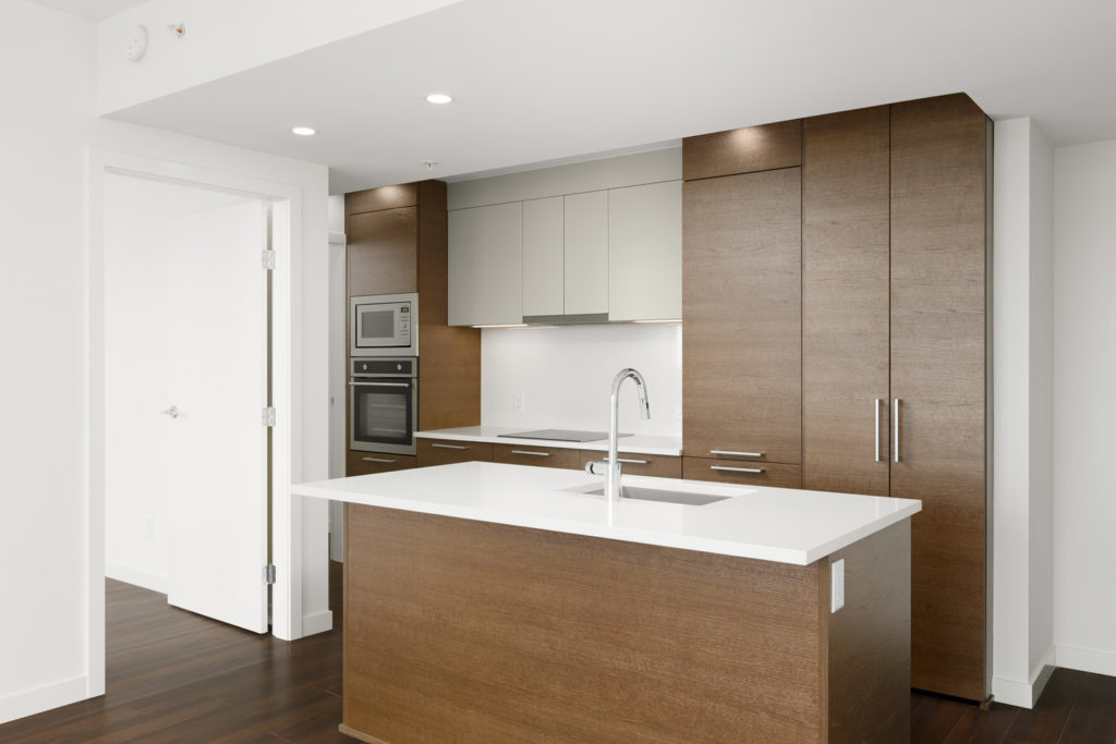 Kitchen with hardwood and white cabinetry inside Vancouver rental condo.