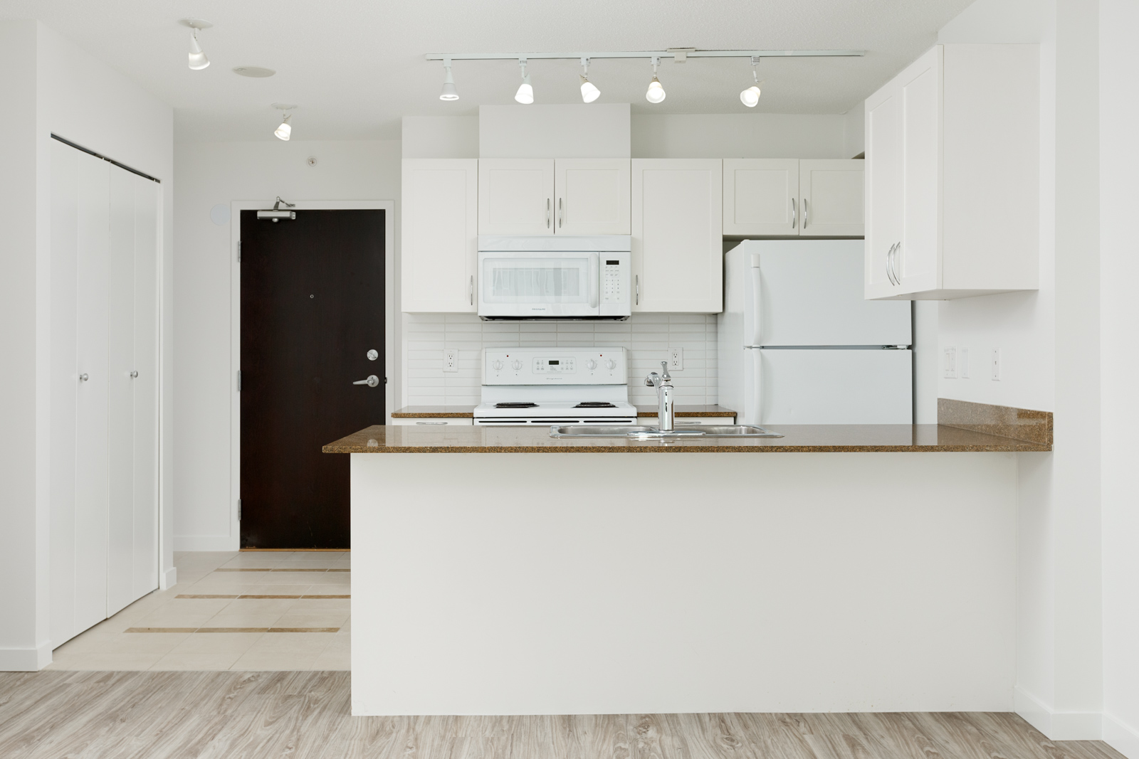Kitchen with white cabinetry inside Vancouver rental condo.