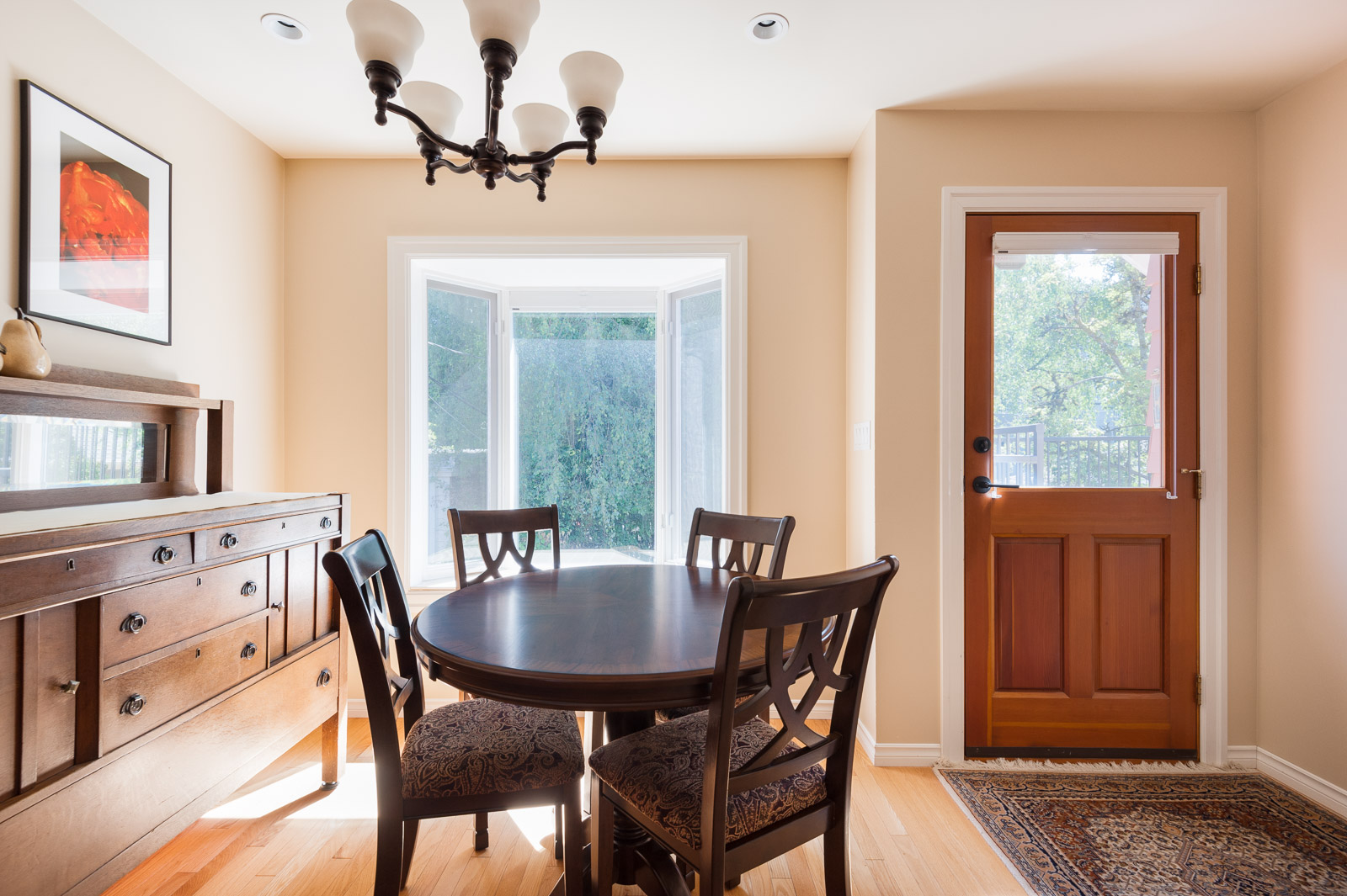 Dining room with circular, wooden table and four chairs inside Westside Vancouver rental listed by Birds Nest Properties.