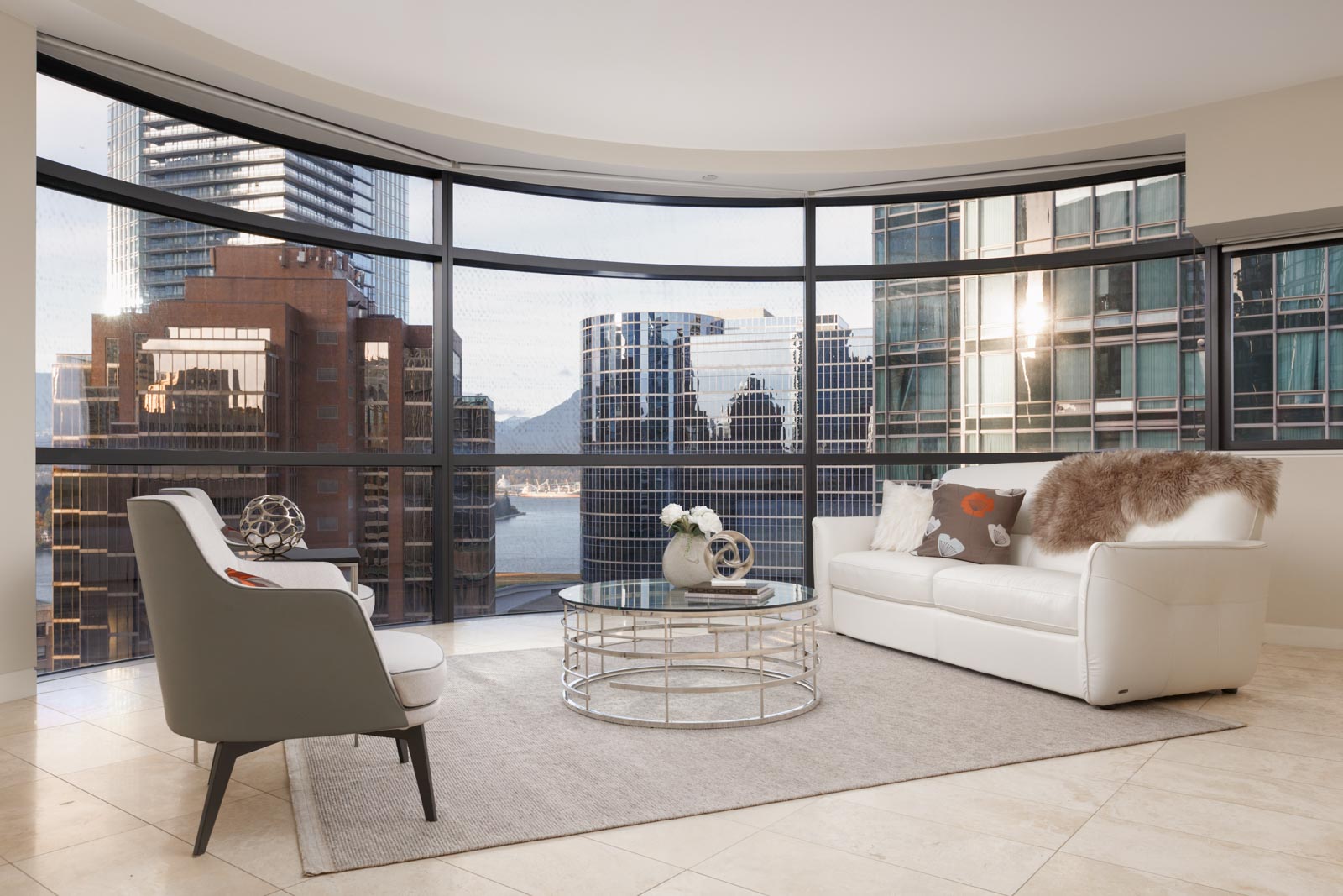 condo living room with sofa chair and table and full windows in downtown vancouver