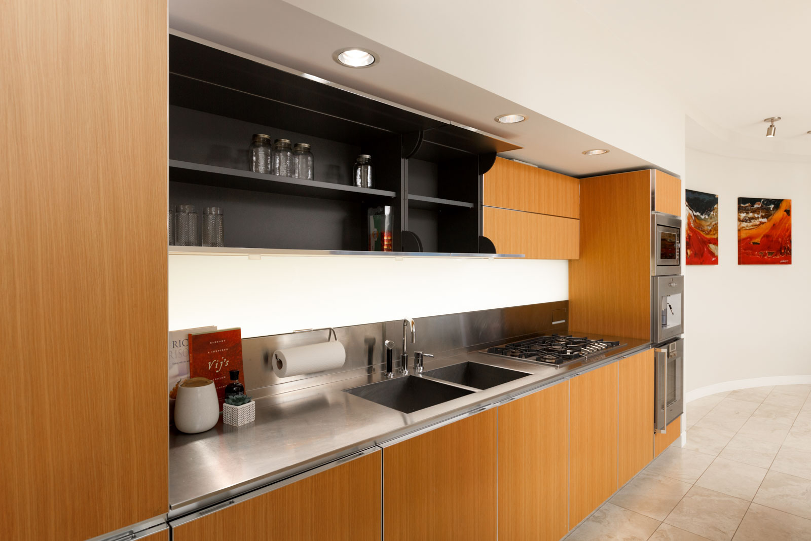 kitchen with wood cabinets and dark overhead shelf in modern condo in jameson house