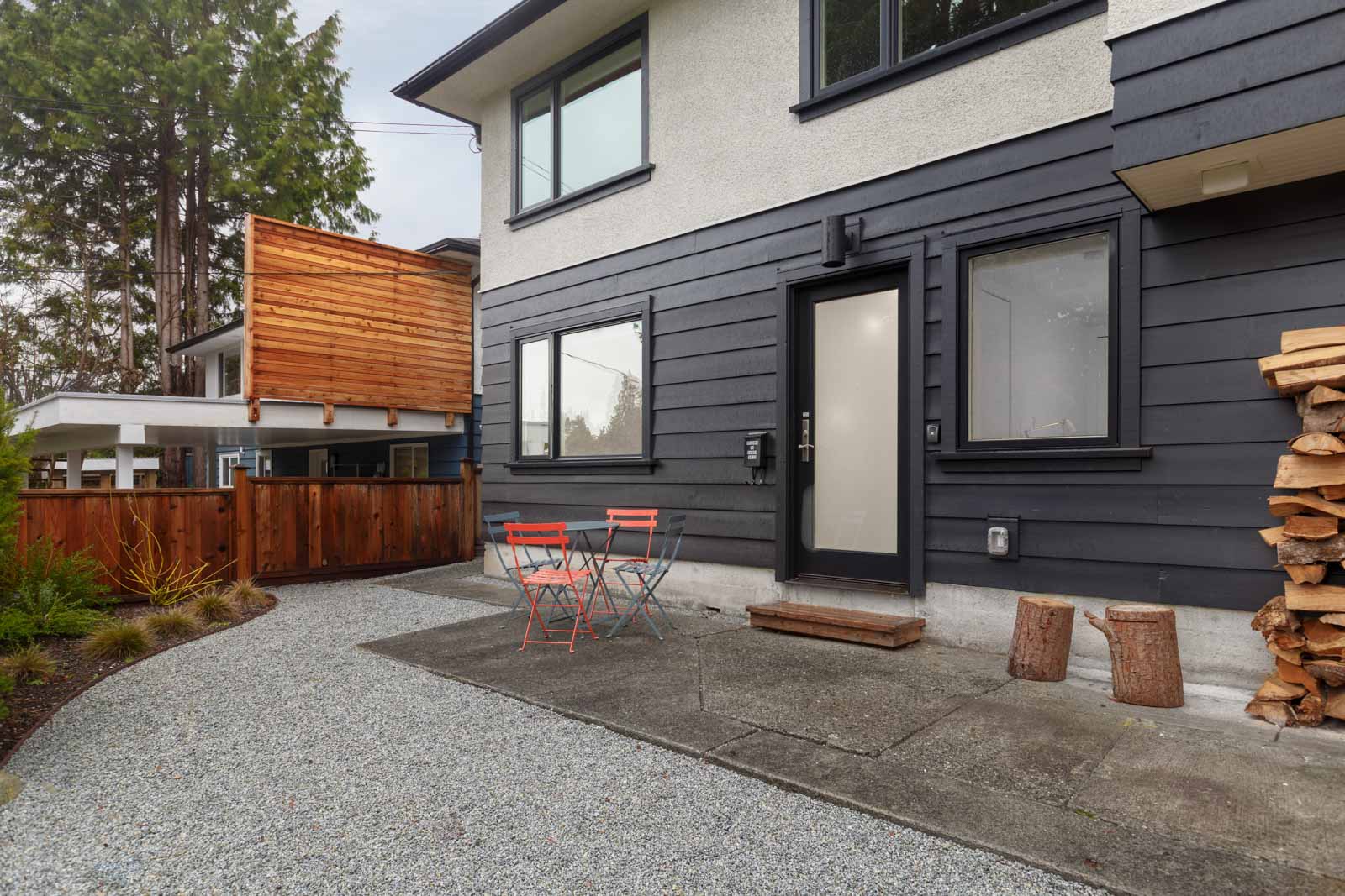 back exterior of modern designed house conversion for rent with door windows and gravel and patio in north vancouver
