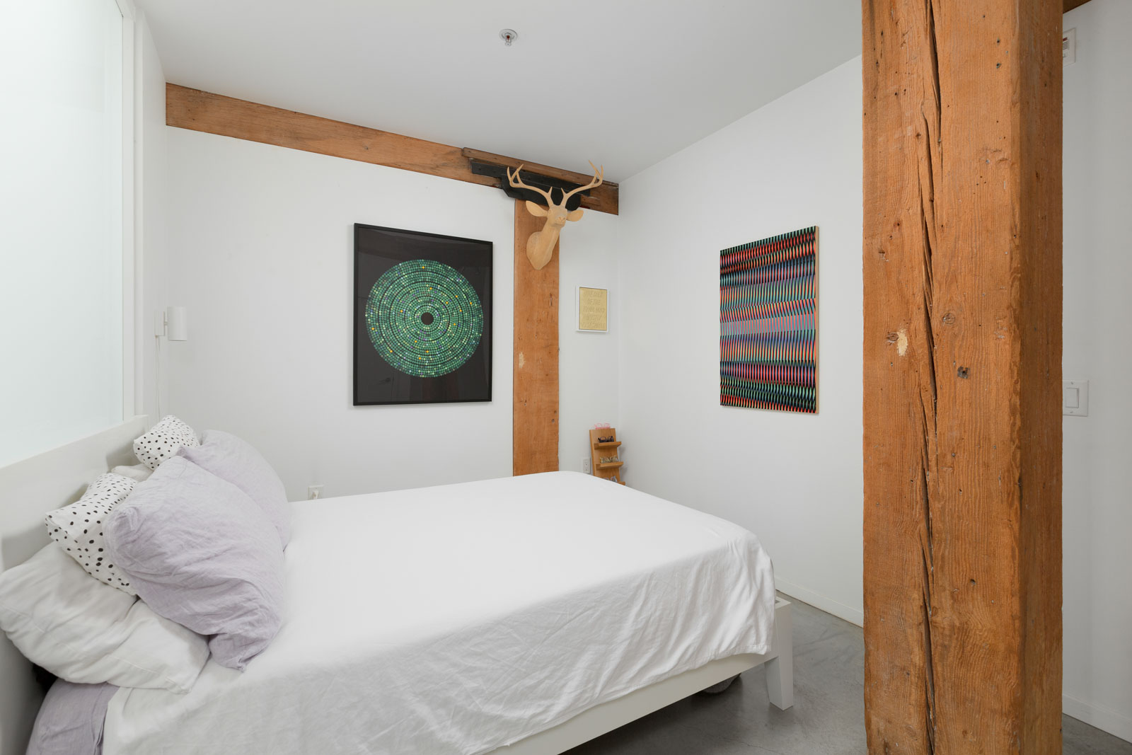 bedroom with wall decor and high ceilings providing an authentic Vancouver rental experience in a rental condo provided by Birds Nest Properties in Vancouver