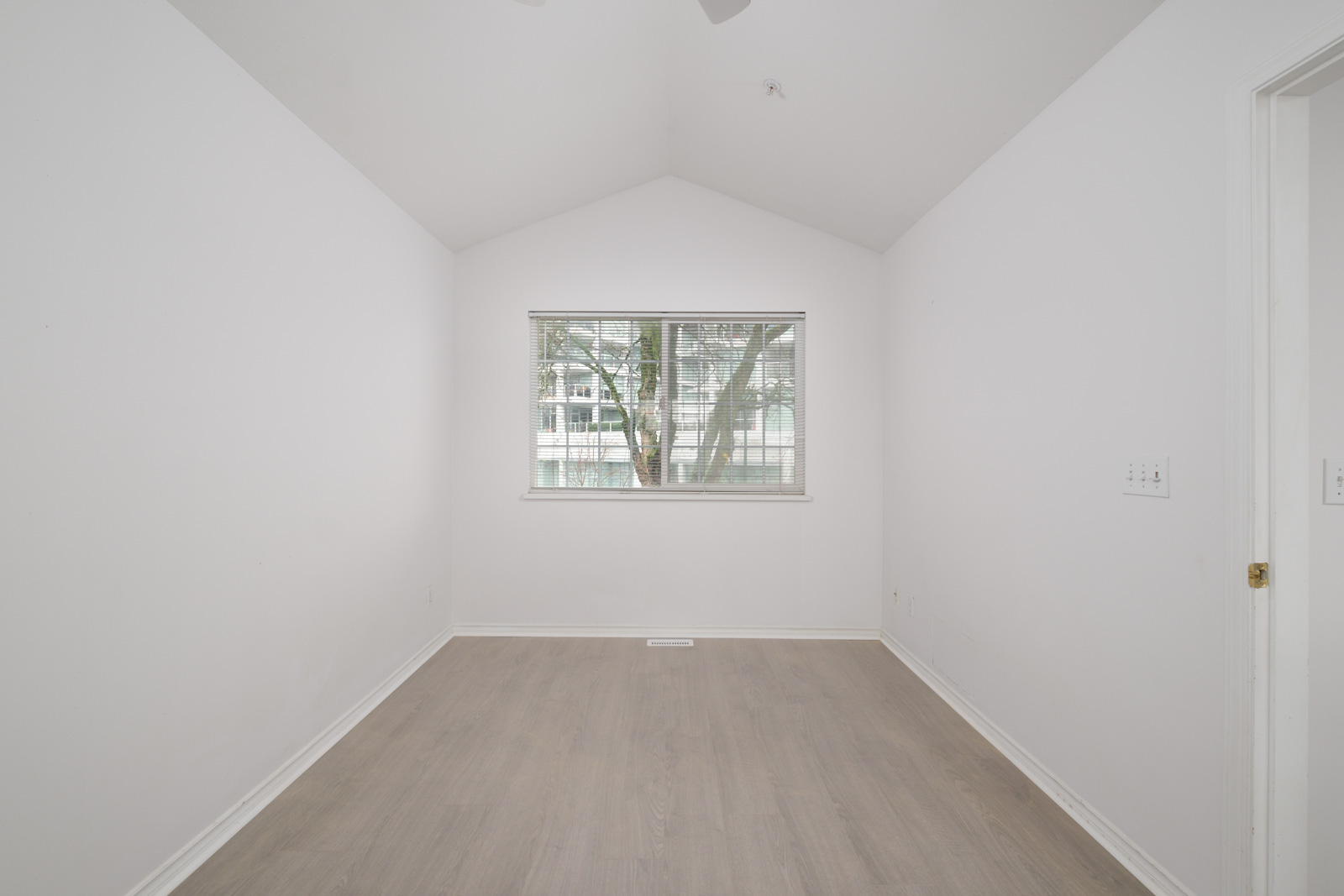 room with hardwood floors and window in background with view of tree in rental house managed by birds nest properties