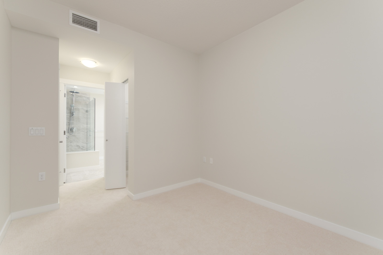 corner of bedroom with white walls and bathroom on left in rental condo in richmond bc near garden city