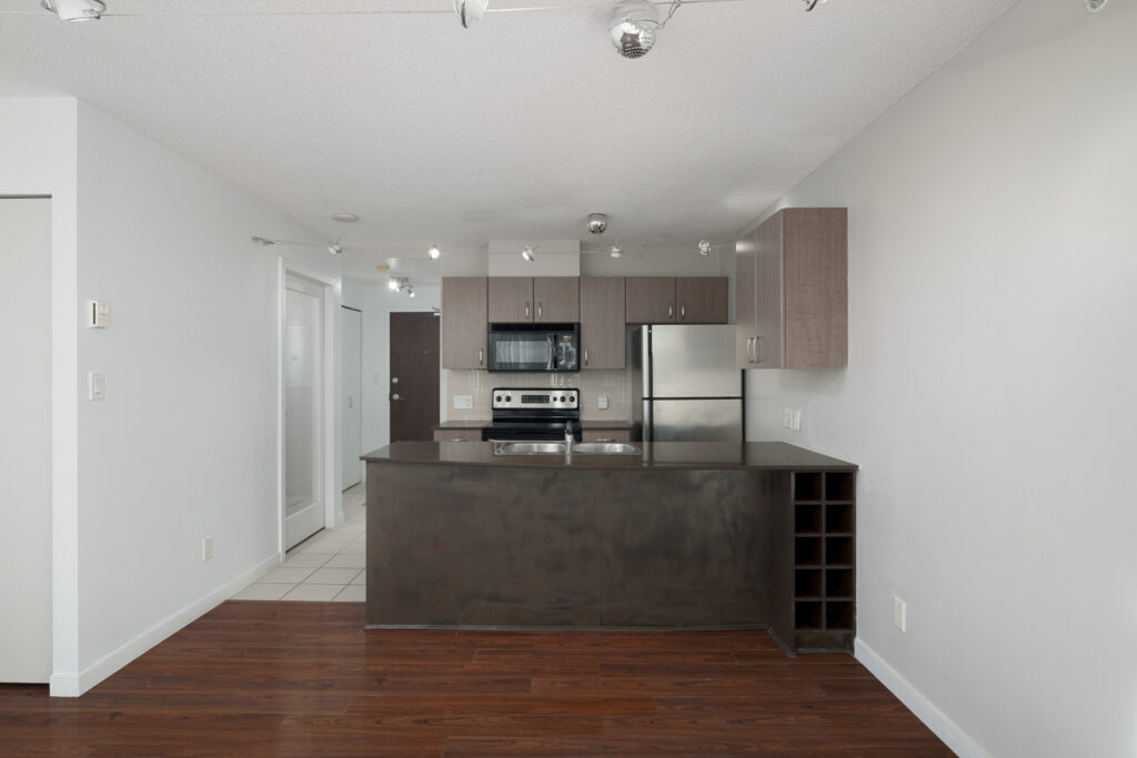 kitchen and living room view with hardwood flooring in rental condo in the downtown vancouver neighbourhood