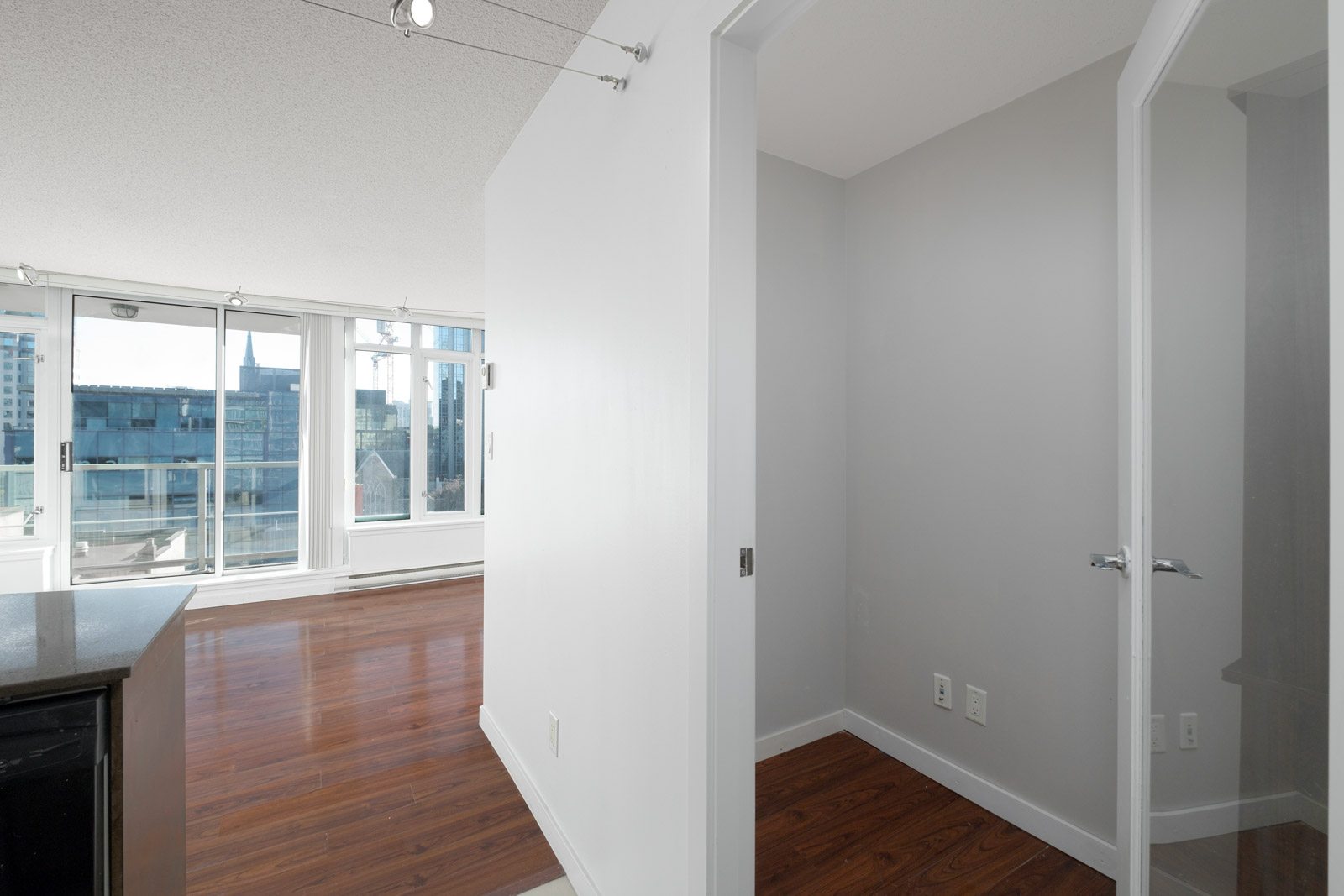 den with grey walls and hardwood floors and floor to ceiling windows in rental house in Vancouver