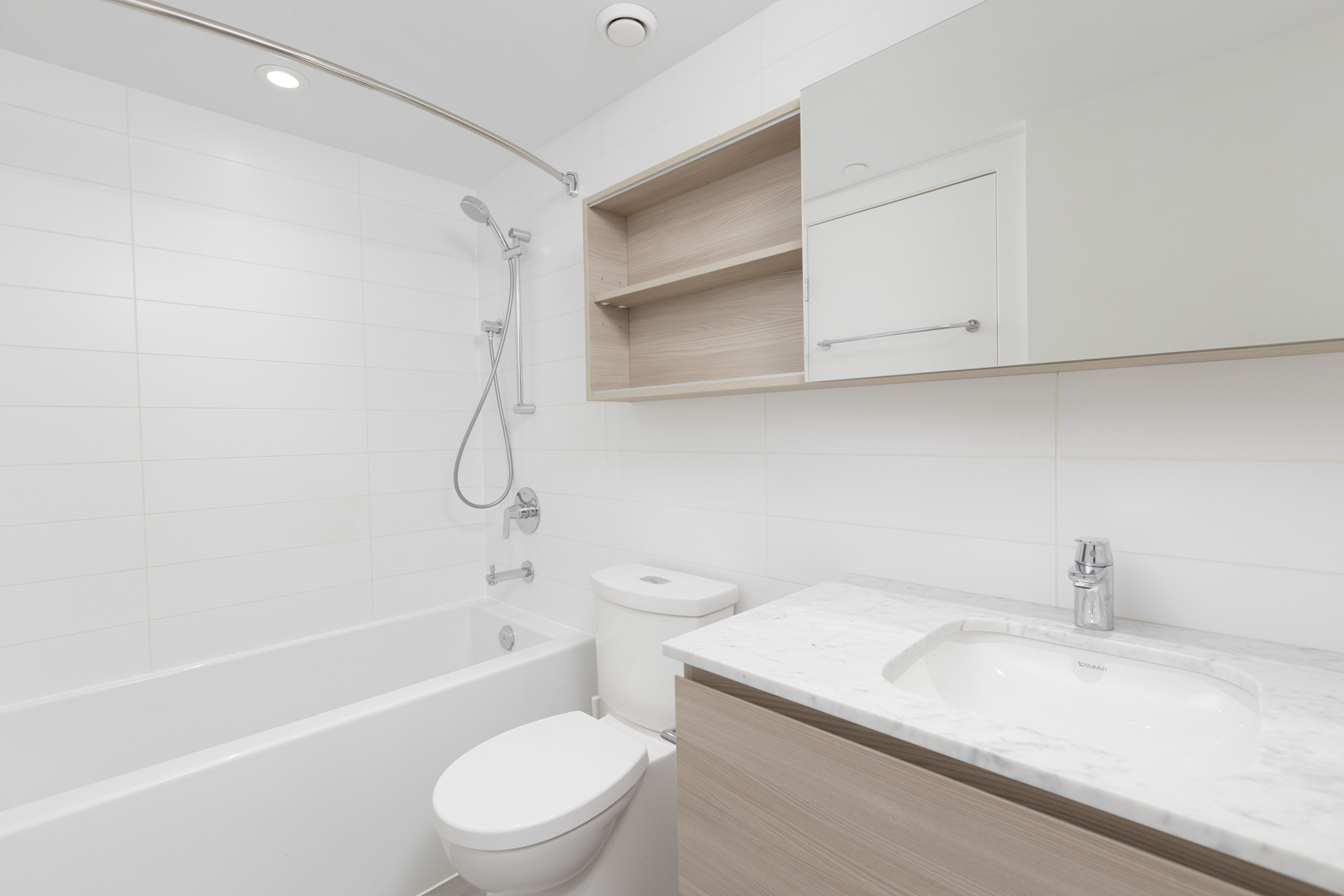 bathroom with a tube and cabinet in a white tones in new Westminster