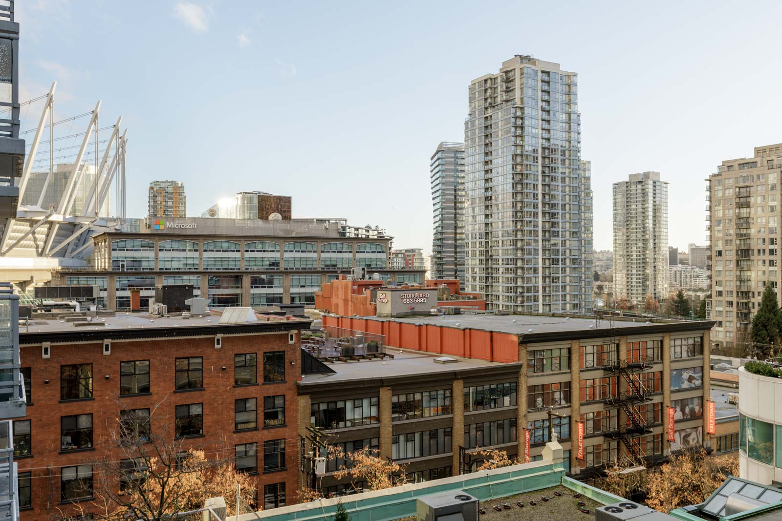 Cityscape view featuring mid-rise and high-rise buildings under a clear sky, with office and residential structures in the foreground.