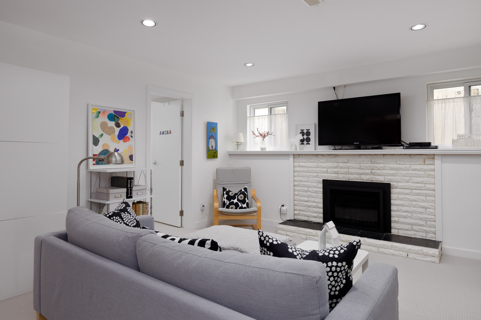 lower living room area with fireplace and carpets, white walls and room