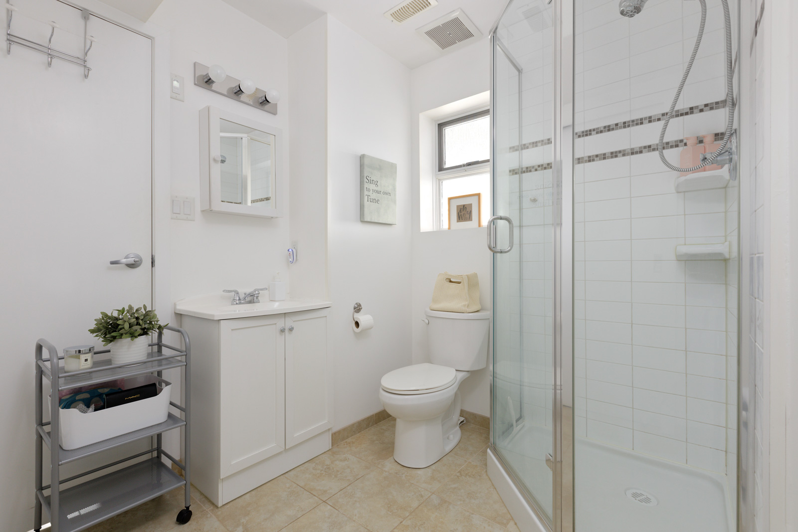 standing shower with all white cabinets and tiled floors