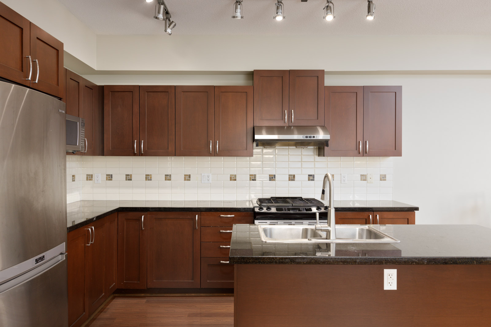 dark brown kitchen cabinets with stainless streel appliances