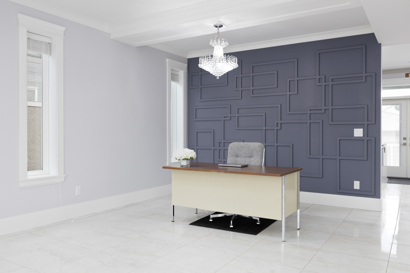 textured dark blue wall with chandelier and tiled floors