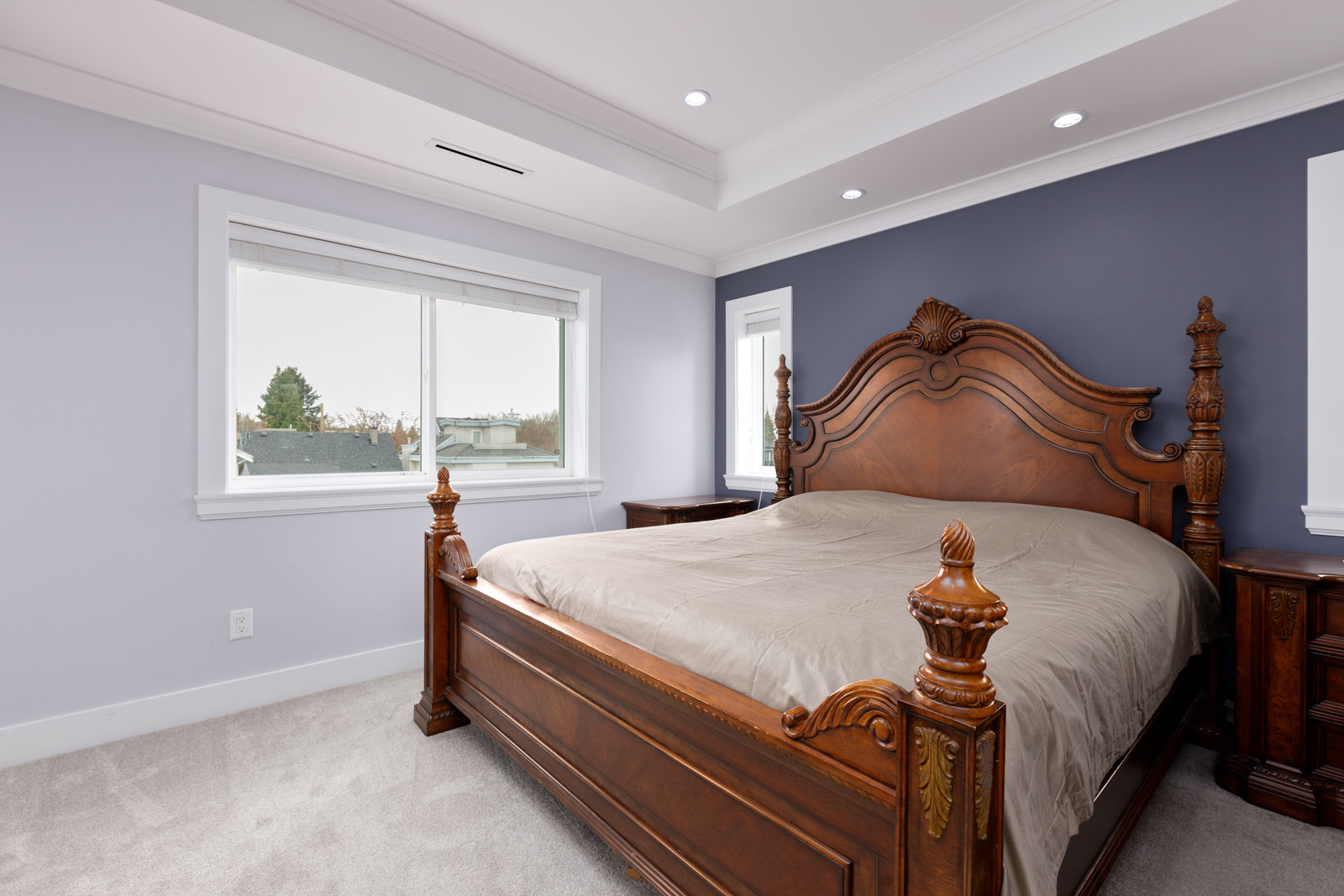 bedroom with two toned walls and pot lights in ceiling. 3 windows