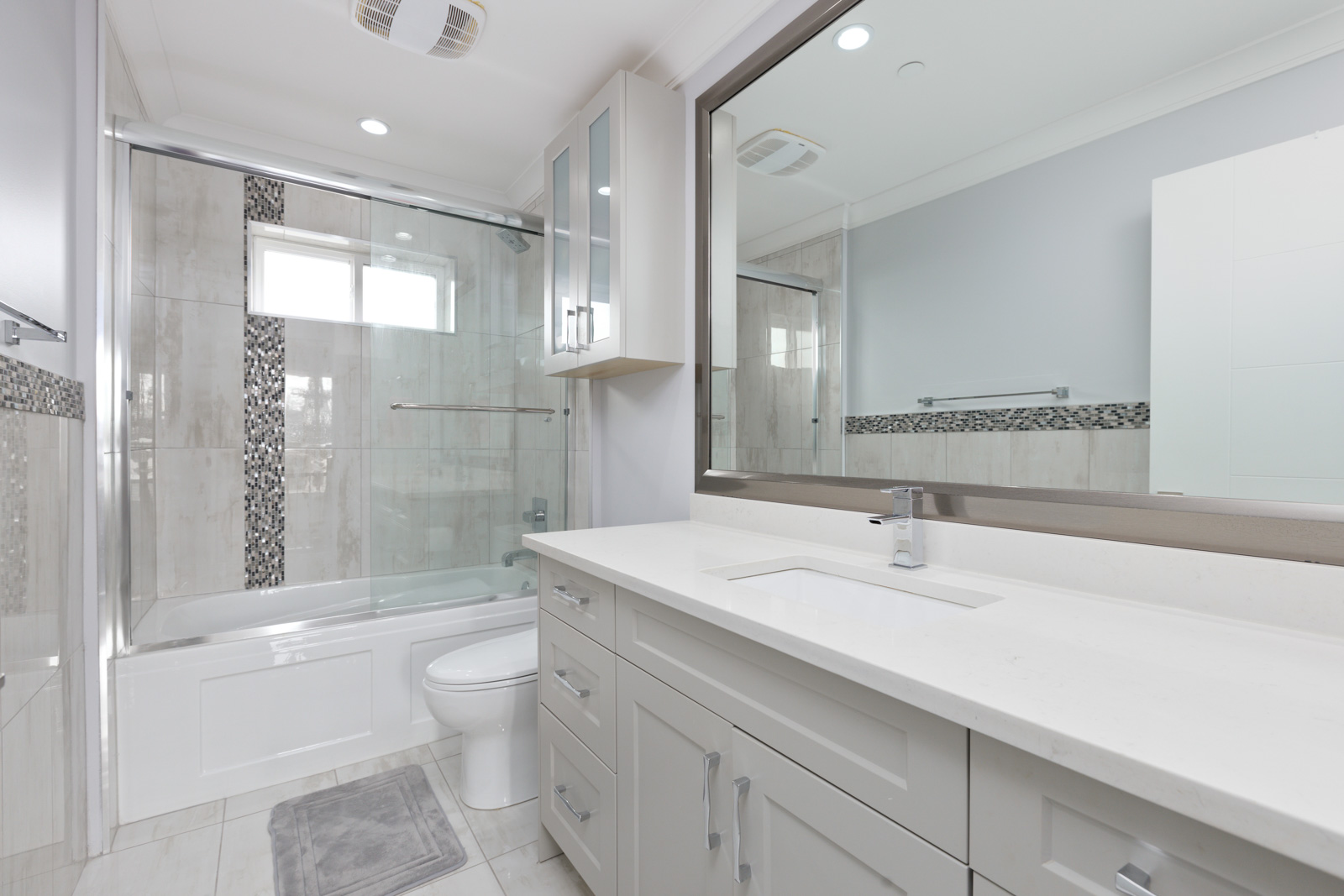 washroom with tiled floors and tub area. large vanity mirror