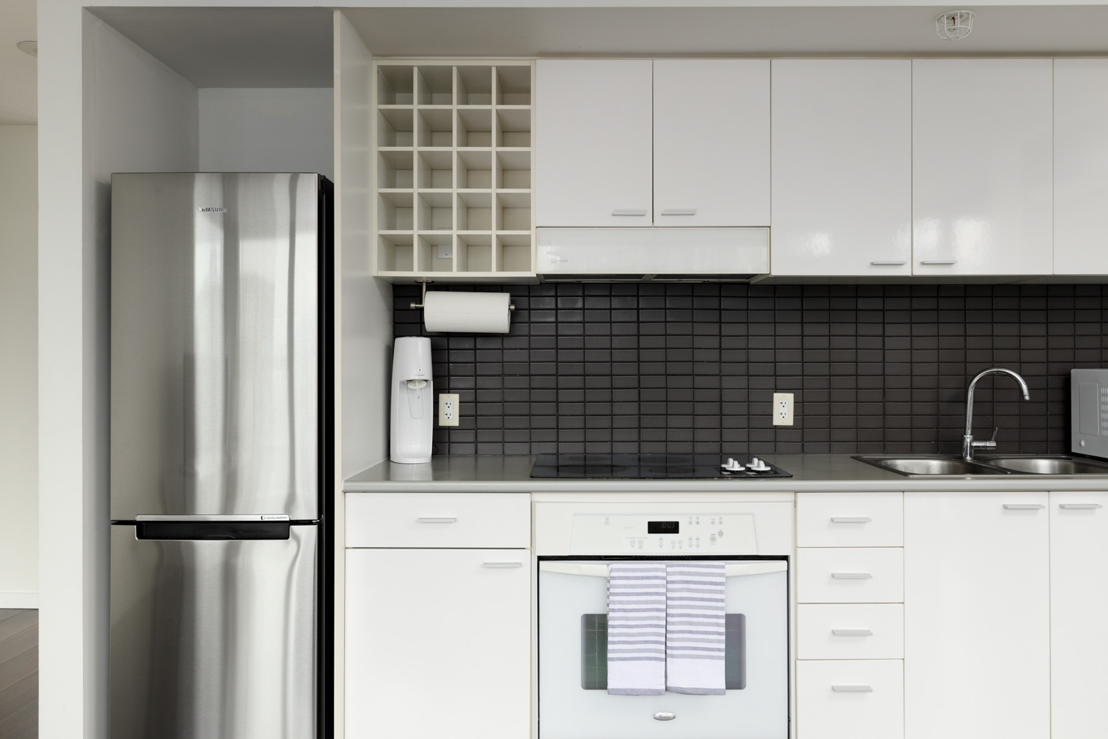 stainless steel fridge with white cabinets and stove
