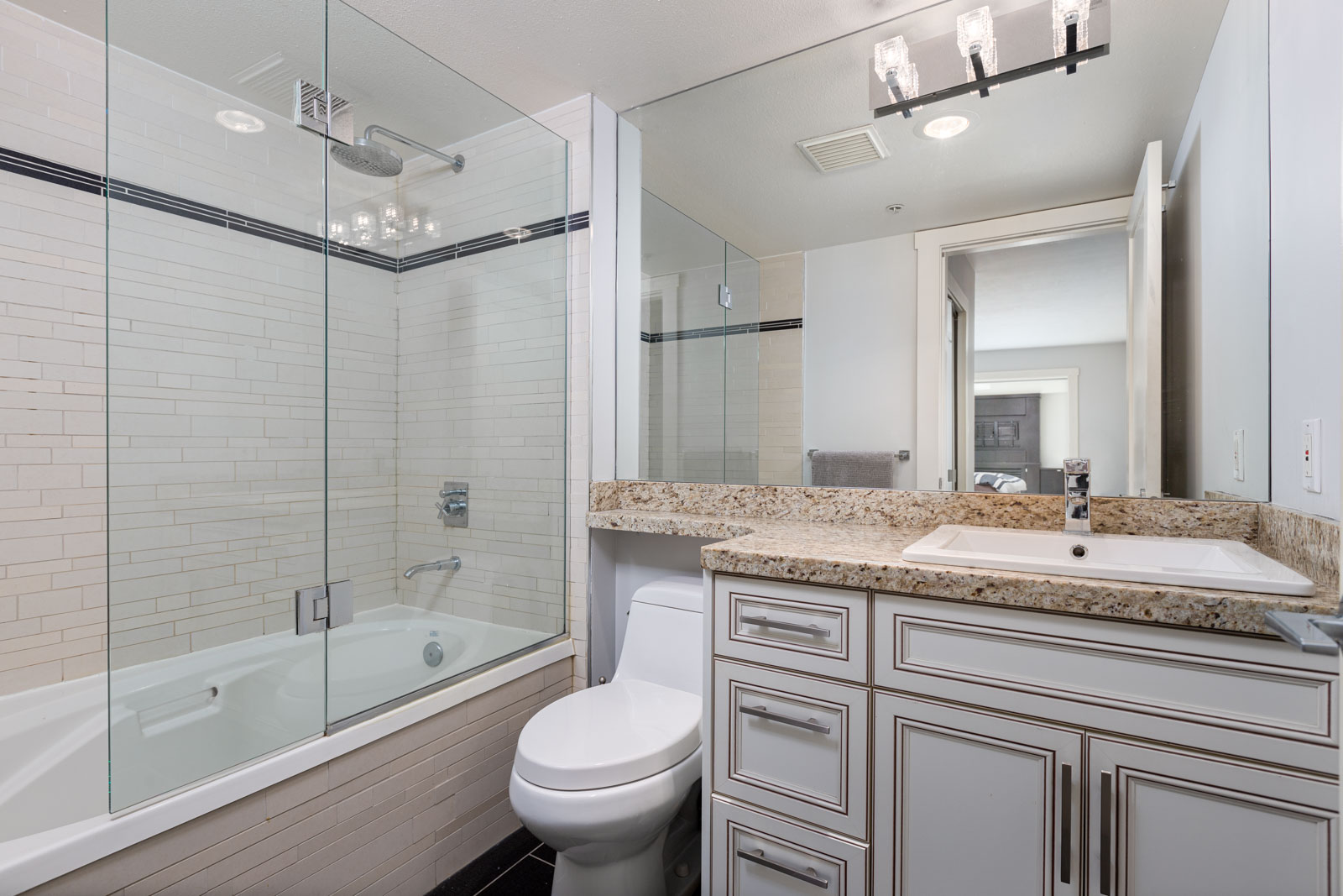 washroom with tub and large mirror