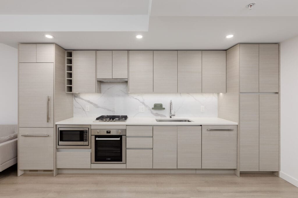 A kitchen with white cabinets and a stove.