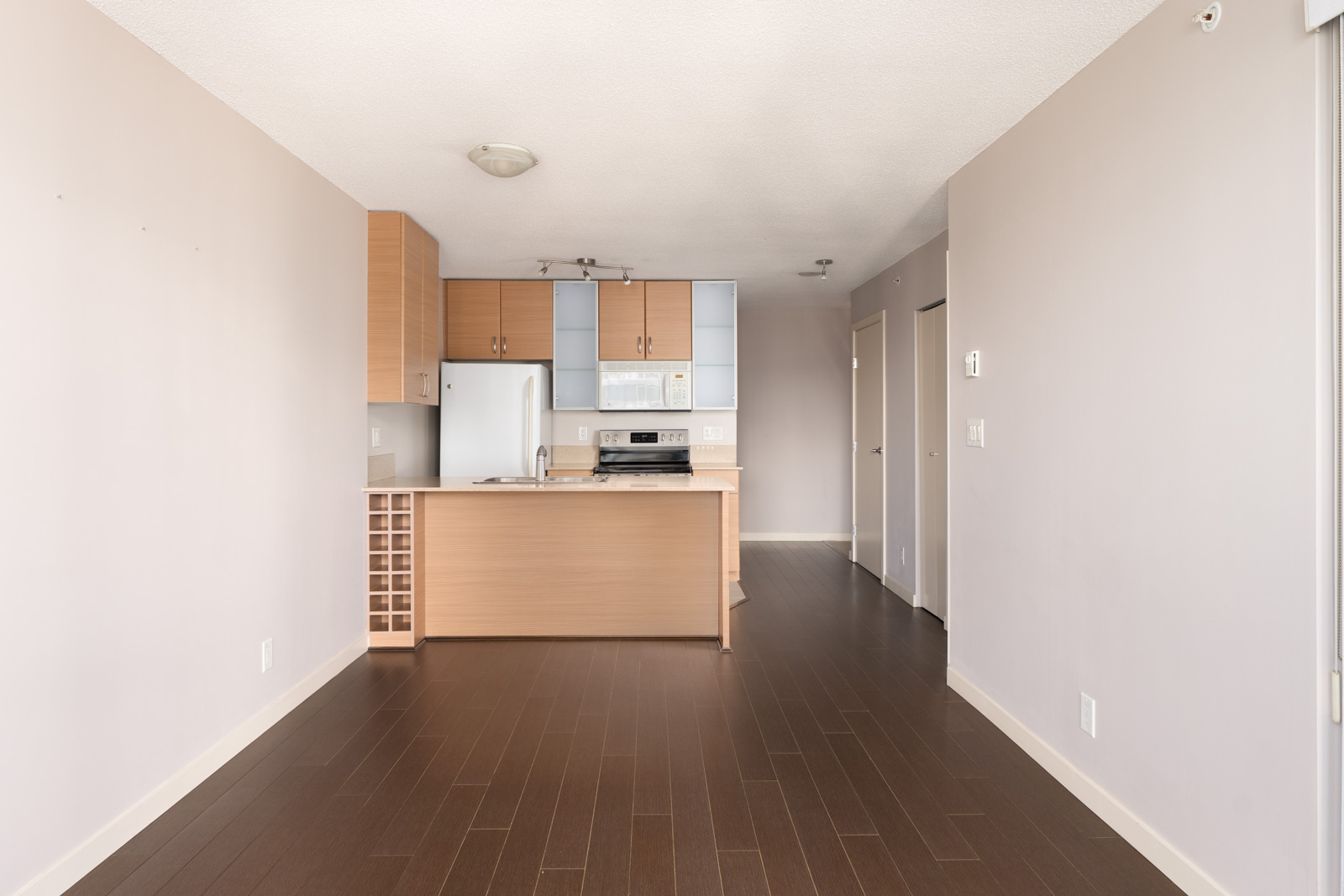 Vacant 23rd-floor Mainland St apartment in Vancouver with light hardwood floors, wood cabinets, white appliances, neutral walls.