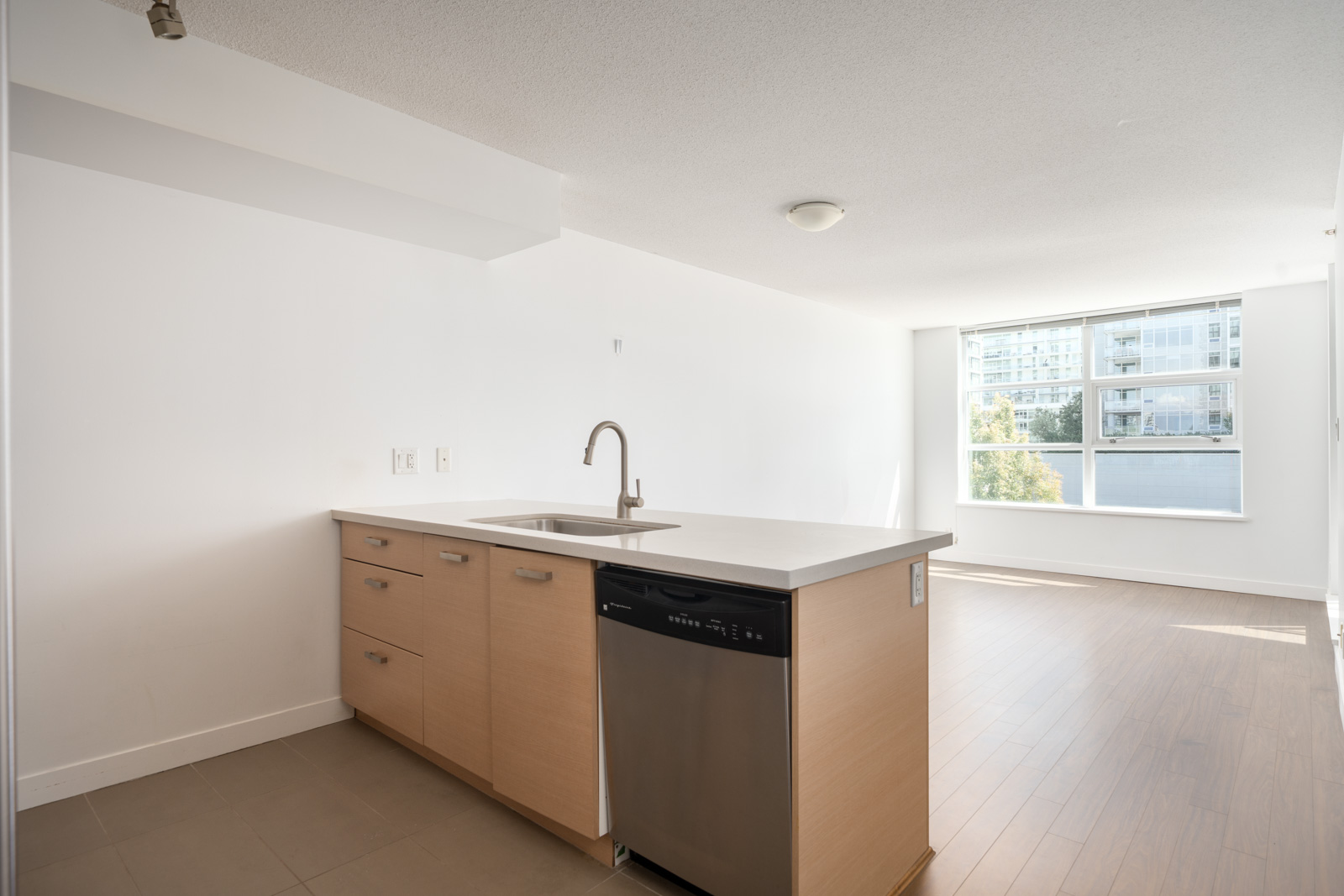 Unfurnished modern 6th-floor apartment on Saba Road, Richmond; light wood kitchen, white counters, stainless dishwasher, large window.