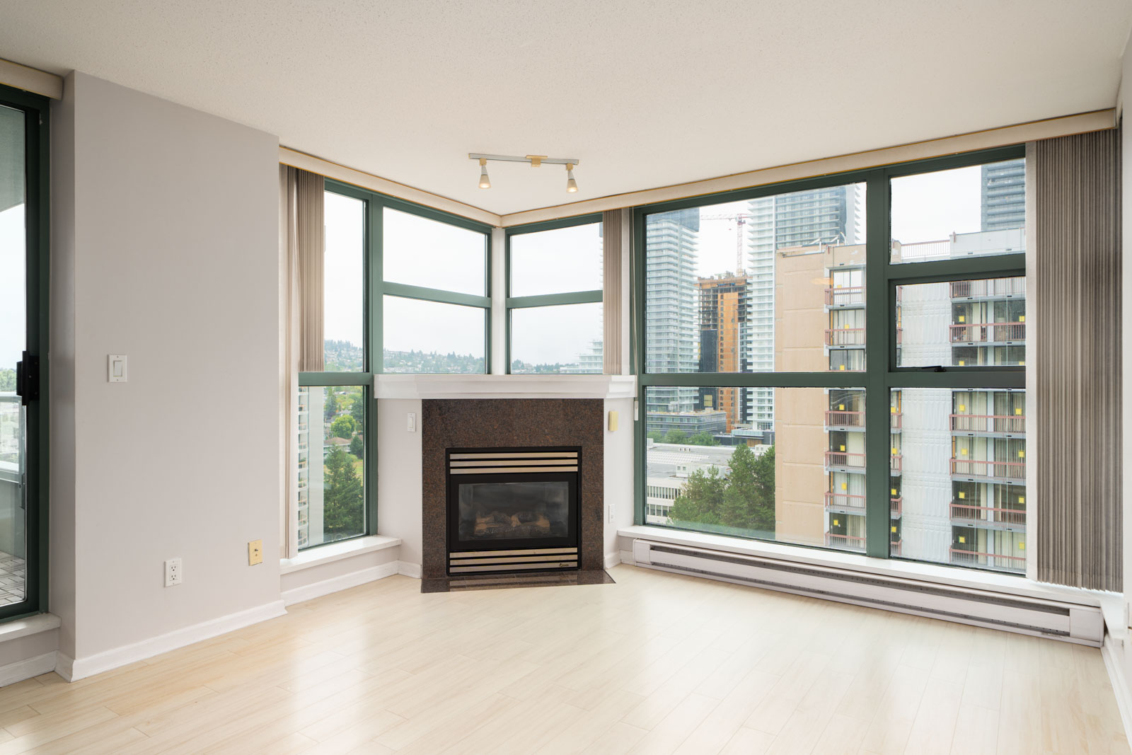 Unfurnished 16th-floor corner apartment at 4380 Halifax St, Burnaby, with large windows, wood floors, fireplace, city views.