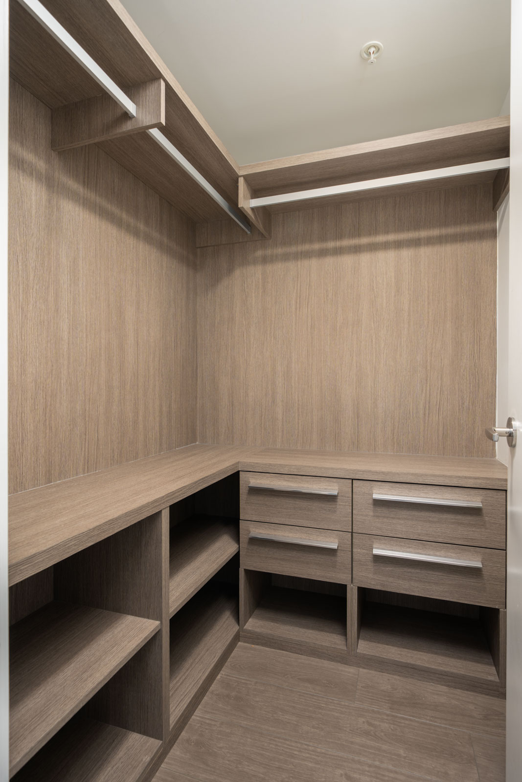 Empty walk-in closet with wooden shelves, drawers, and open storage, seen from the doorway under ceiling light at 6320 No.3 Rd, Richmond.