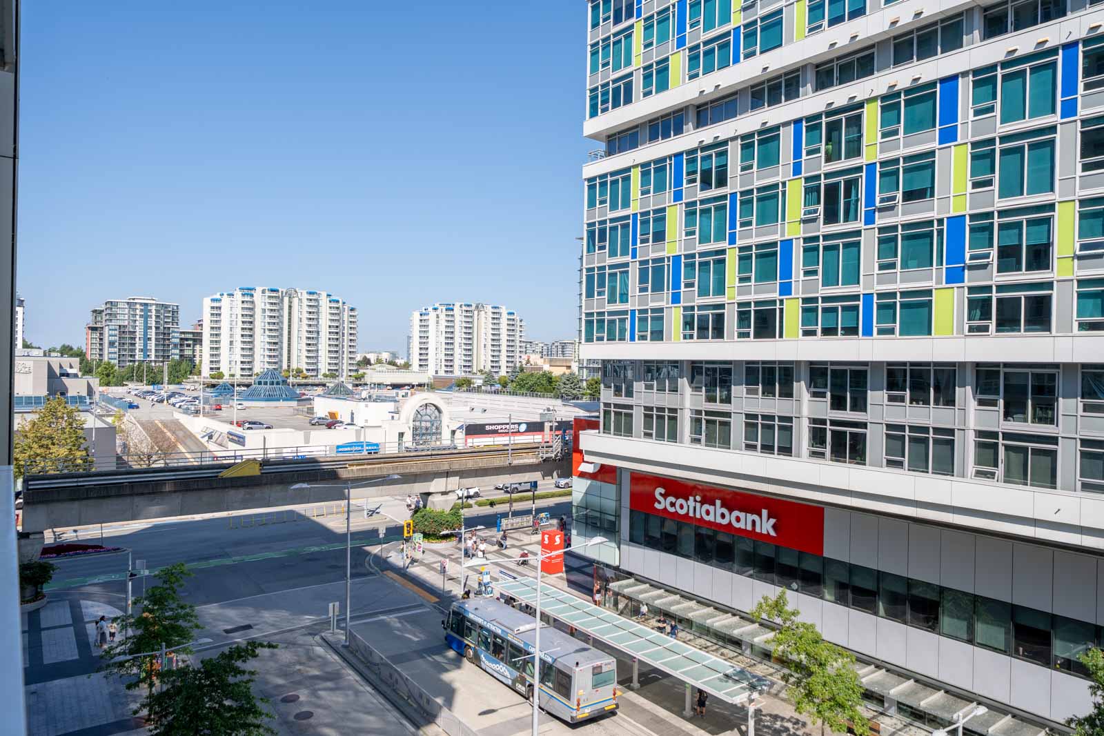 Street view of Scotiabank at 6320 No.3 Rd, Richmond, with a stopped bus, high-rise apartments behind, and clear blue sky.
