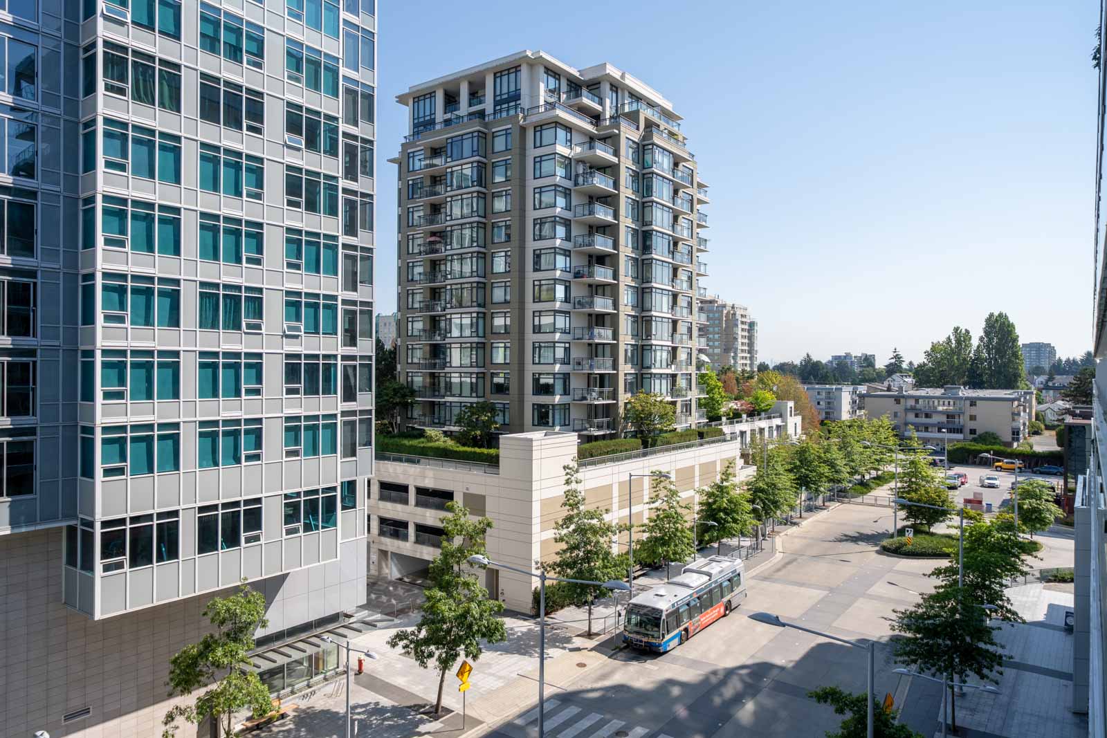 Mid-rise apartments at 6320 No.3 Rd, Richmond, line a sunny, tree-lined street; a bus waits at the intersection below.