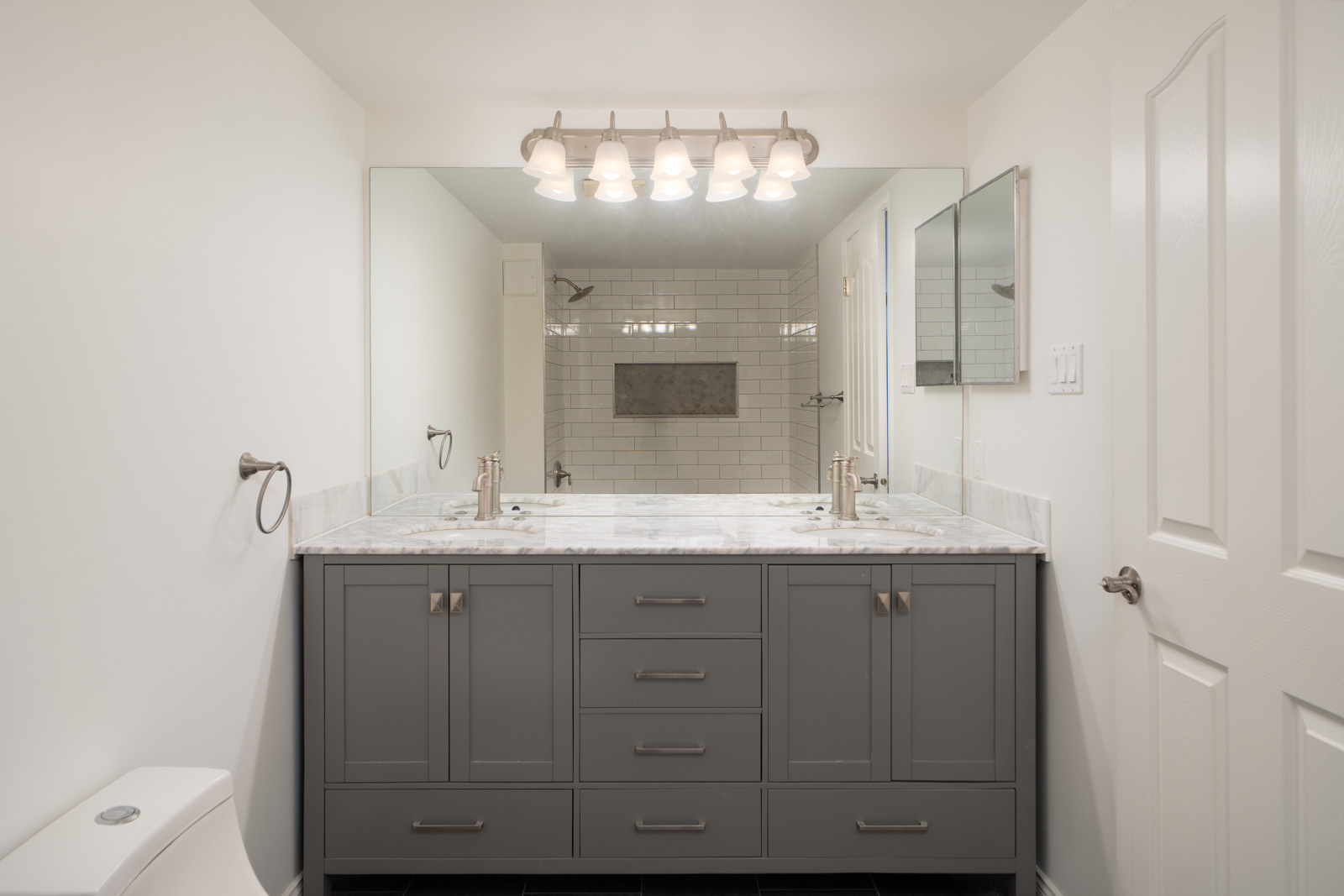 Modern bathroom on 12th Floor, 1245 Quayside Dr, New Westminster with double-sink gray vanity and white tiled shower.