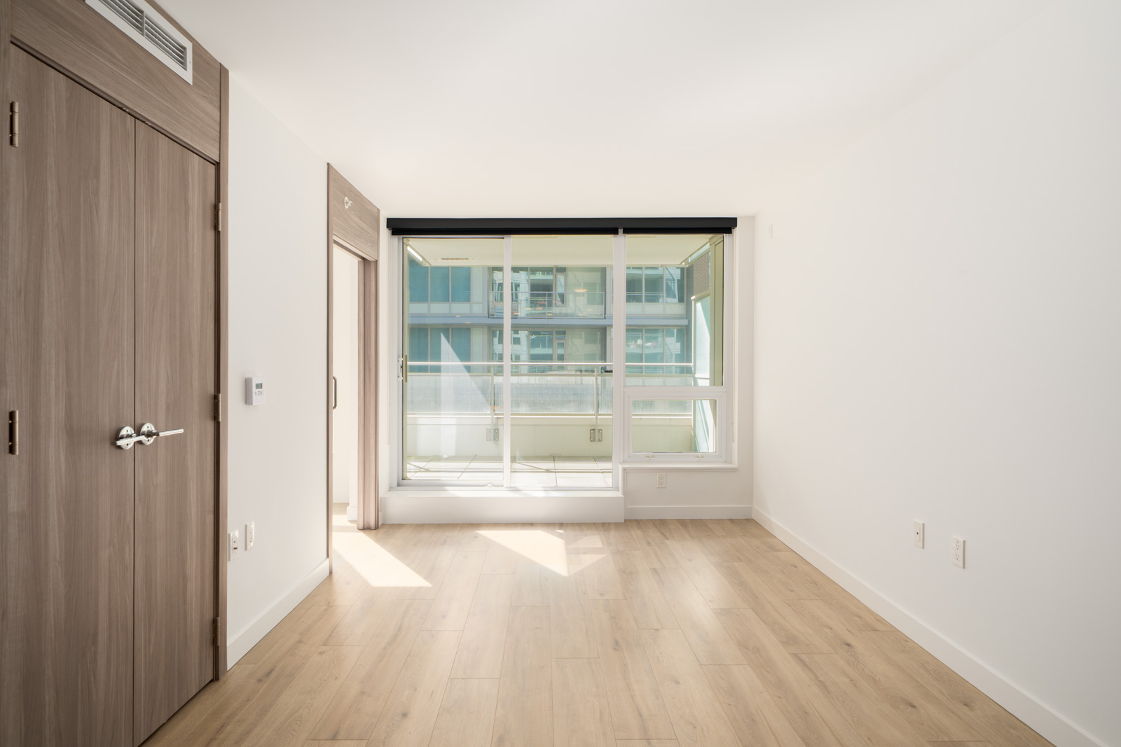Unfurnished room on SW Marine Dr, Vancouver, with light wood floors, white walls, big window, sliding door, and wooden closet.