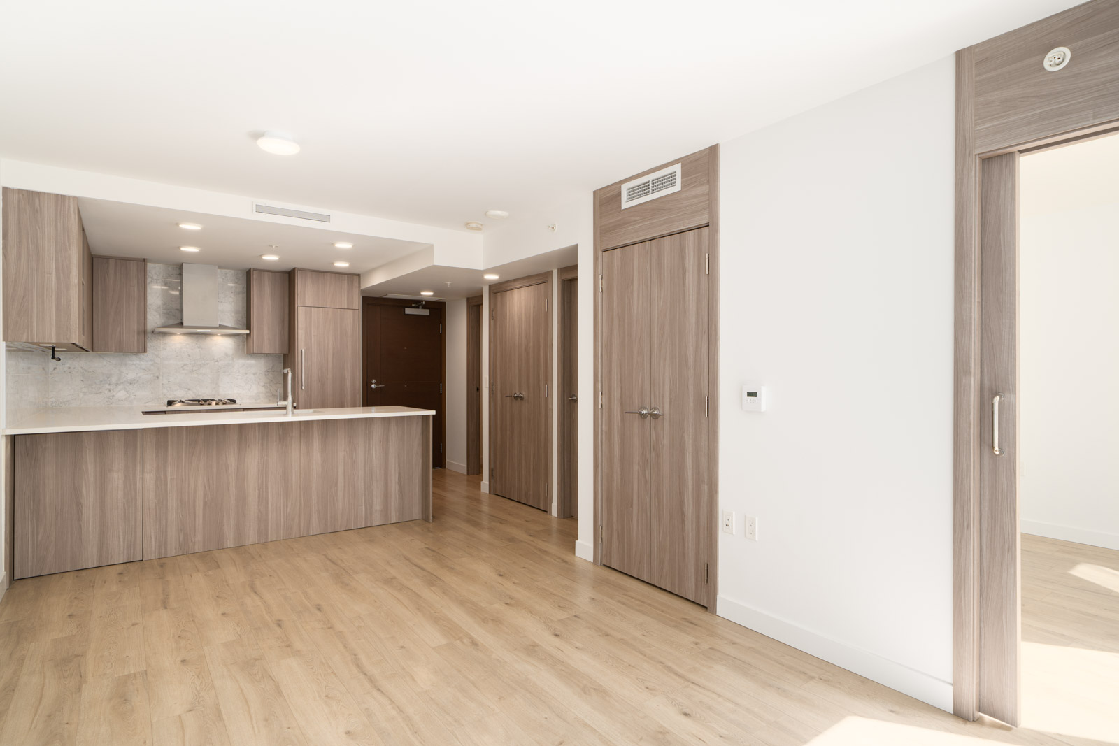 Modern apartment near SW Marine Dr, Vancouver, with wood floors, open kitchen with wood cabinets, and well-lit space.