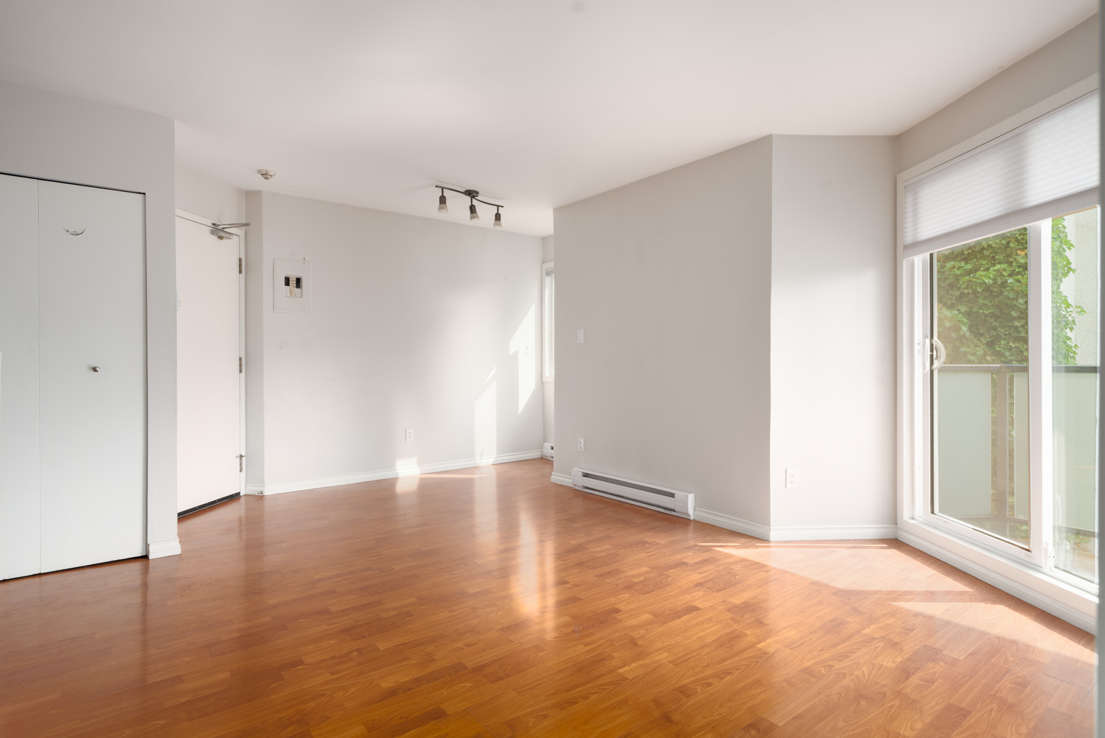 Unfurnished room on 2nd Floor, West 5th Avenue, Vancouver; light walls, wood floor, ceiling lights, closet, heater, large window.