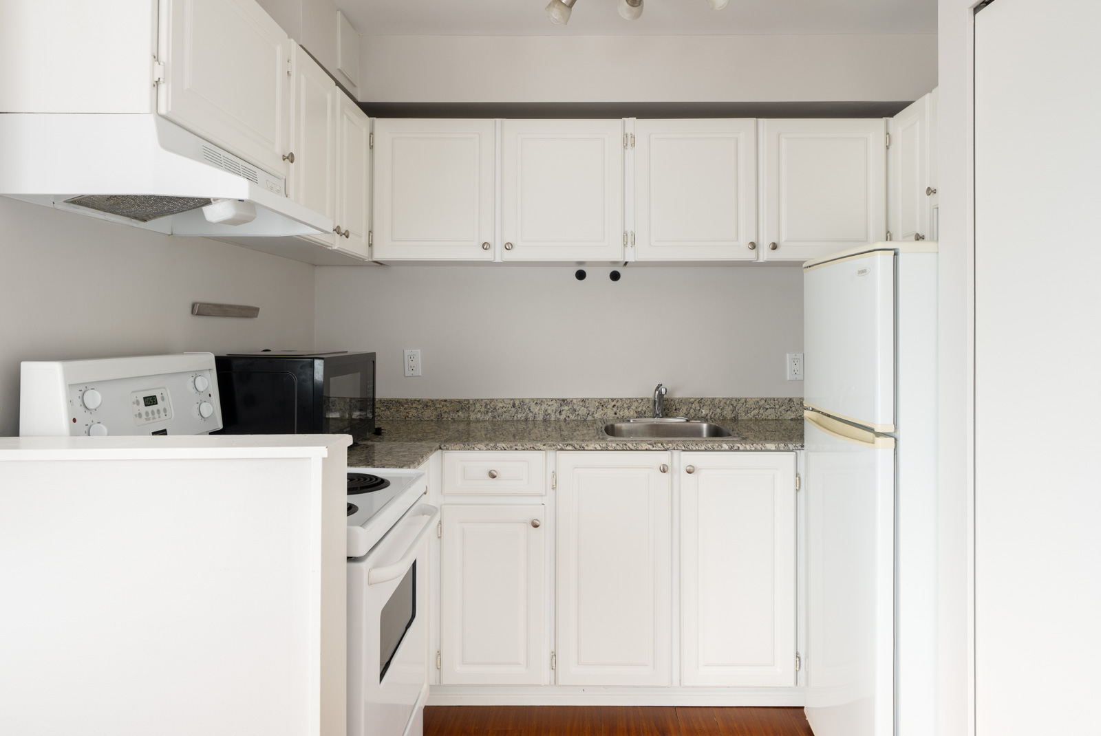Small kitchen on 3rd floor at 2365 West 5th Ave, Vancouver, with white cabinets, appliances, granite countertop, and bright lighting.
