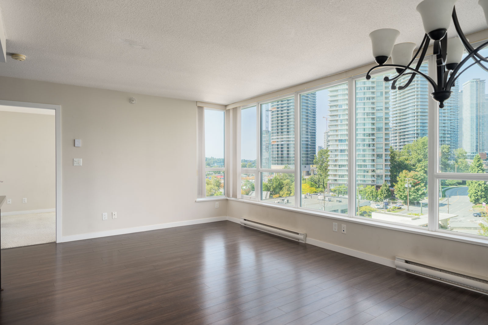 Corner apartment room on 7th floor at 2232 Douglas Rd, Vancouver, with large windows, hardwood floors, and city views.