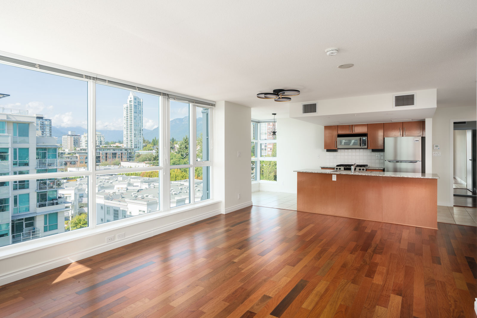Modern apartment on 12th floor at 188 E Esplanade, North Vancouver, with large windows showing city and mountain views.