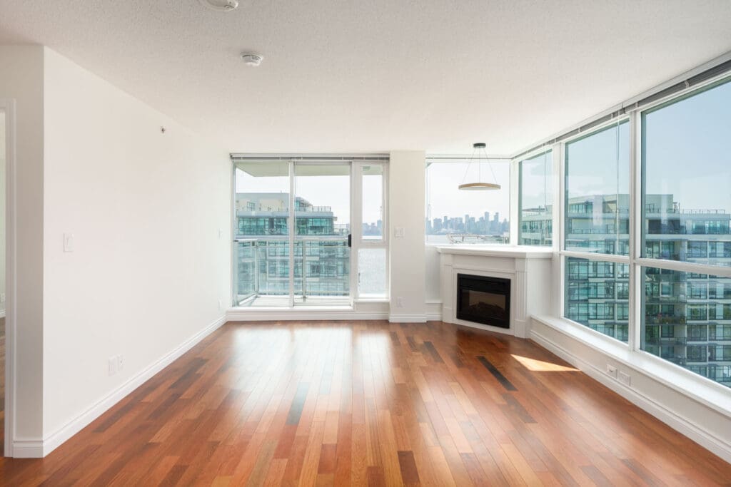 Corner apartment at 188 E Esplanade, North Vancouver with wood floors, large windows, modern fireplace, and city and water views.