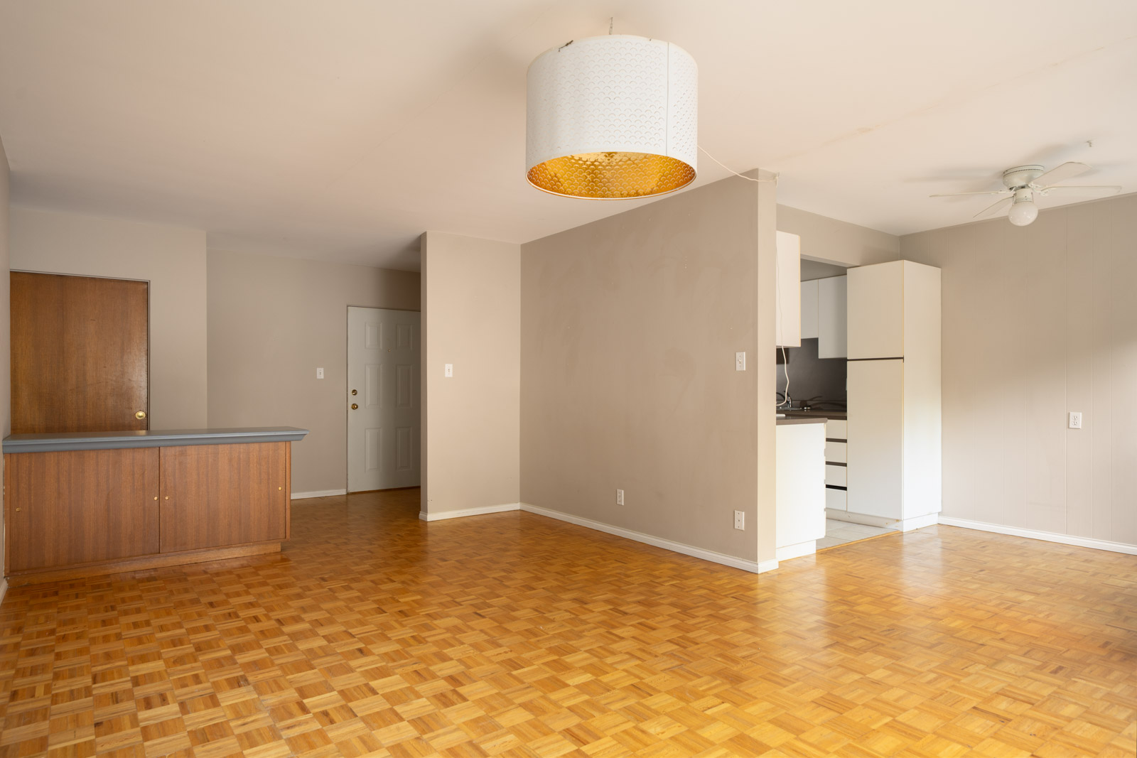 Unfurnished apartment at 1970 W 41st Ave, Vancouver, with parquet floors, neutral walls, ceiling light, kitchen, and closed doors.