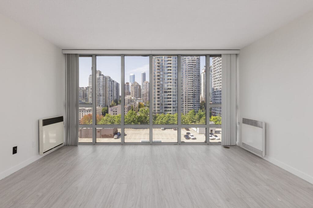 Unfurnished apartment room at 950 Cambie St, Vancouver, with large windows, light wood floors, and cityscape plus parking lot views.