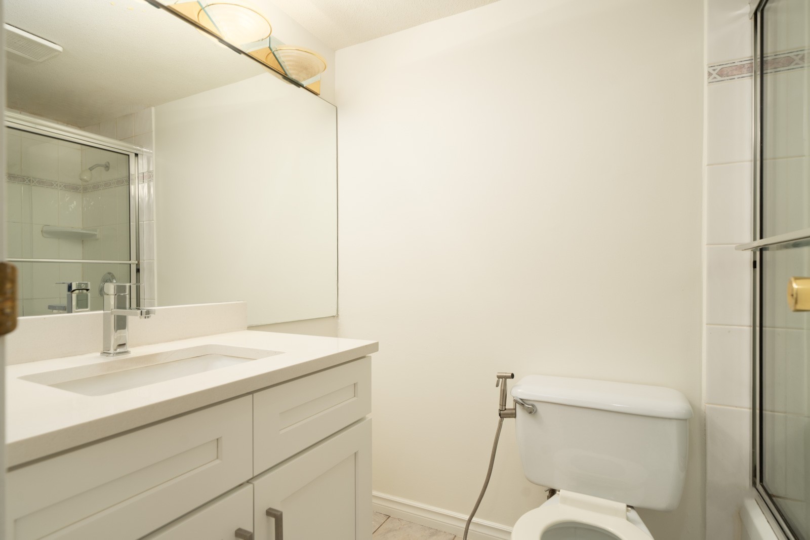 Modern bathroom on 1st Floor, Ackroyd Rd, Richmond, with white vanity, large mirror, bidet toilet, and glass shower; all-white décor.