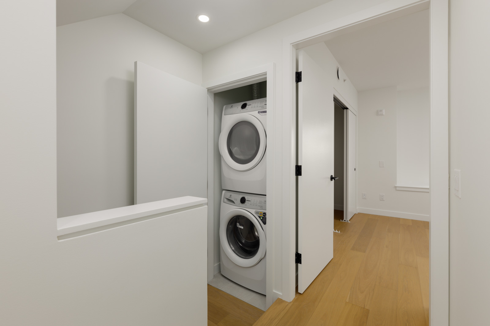 Stacked front-loading washer and dryer in a closet alcove at 5433 Oak Street, Vancouver.