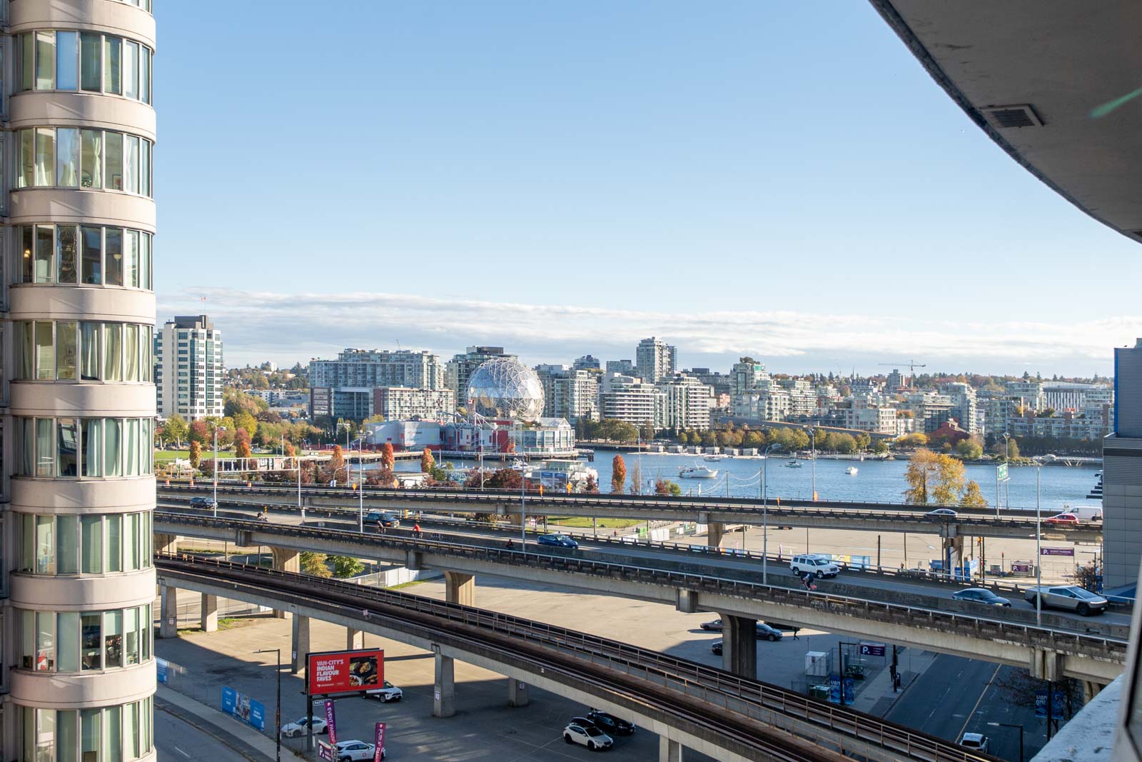 10th-floor view of Vancouver’s False Creek, featuring the Science World dome, city skyline, and bridge traffic.