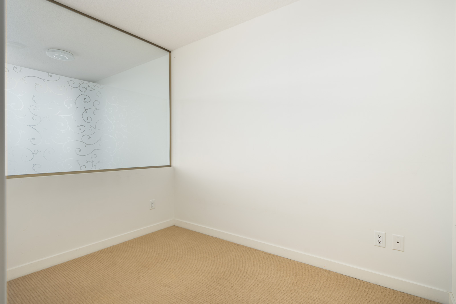 Empty room with beige carpet, white walls, and a large decorative glass interior window at 4818 Eldorado Mews.