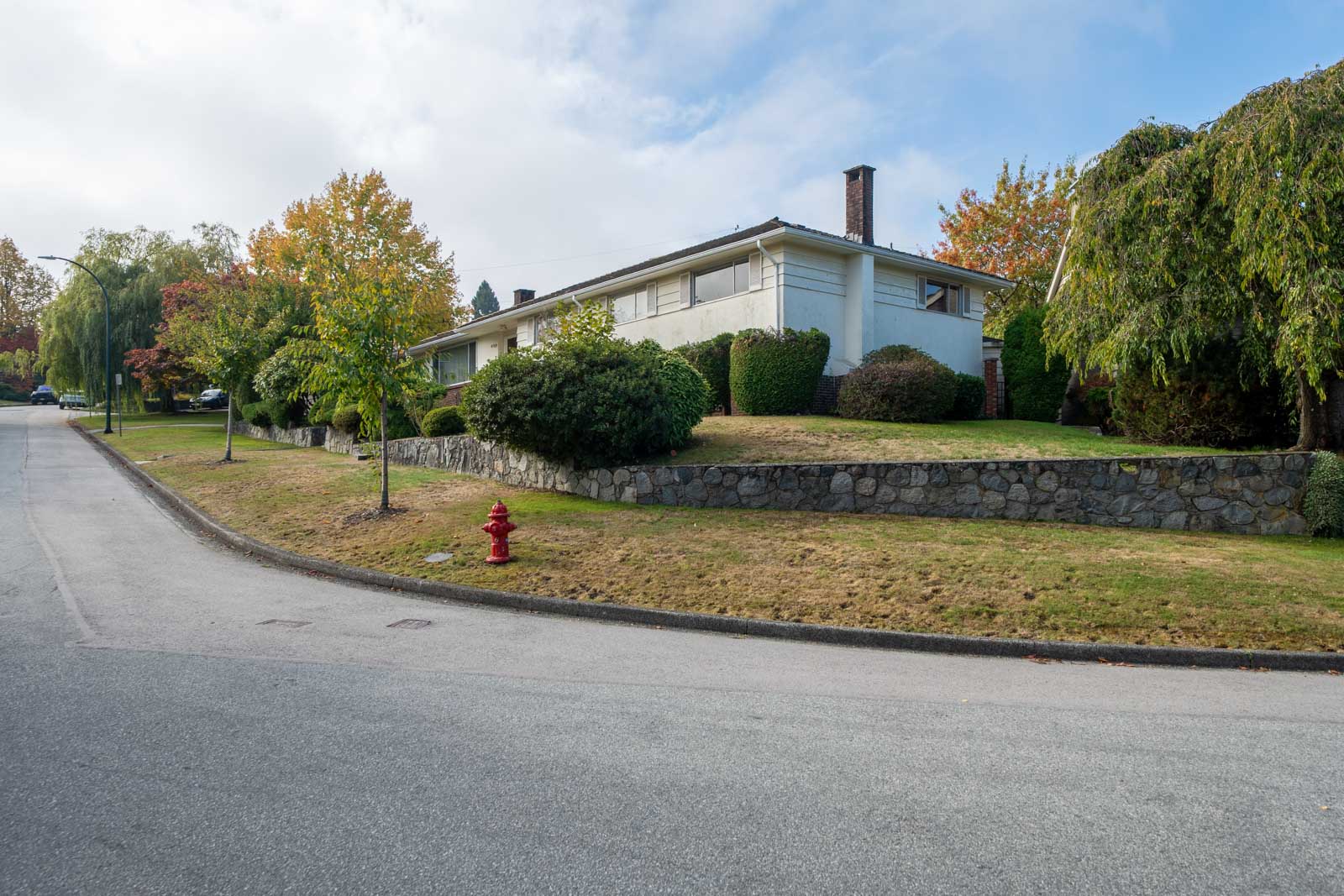 Single-story ranch house on the corner of Haggart and Paton Street with a stone retaining wall and foreground hydrant.