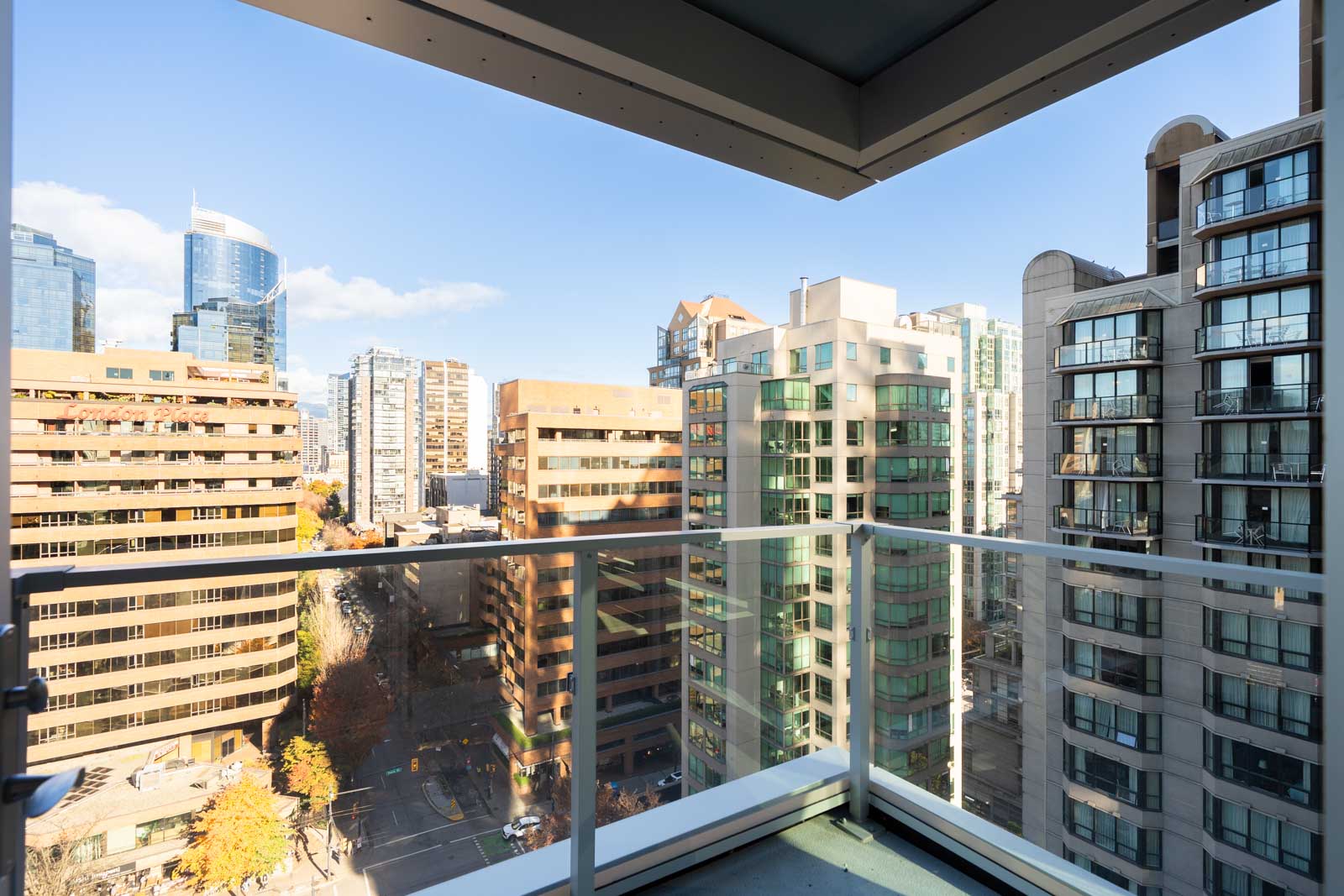 Downtown Vancouver skyline viewed from a balcony with a glass railing.