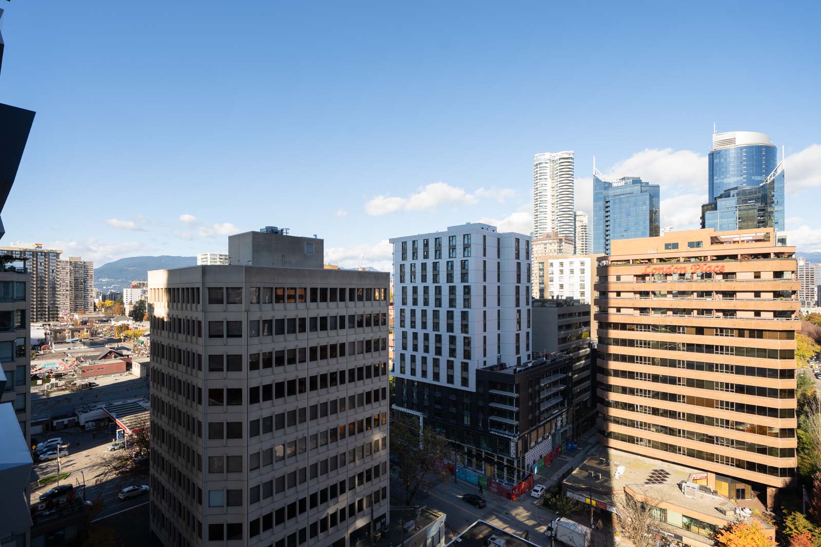 High-angle view of the Vancouver skyline with office and residential buildings under a clear blue sky.
