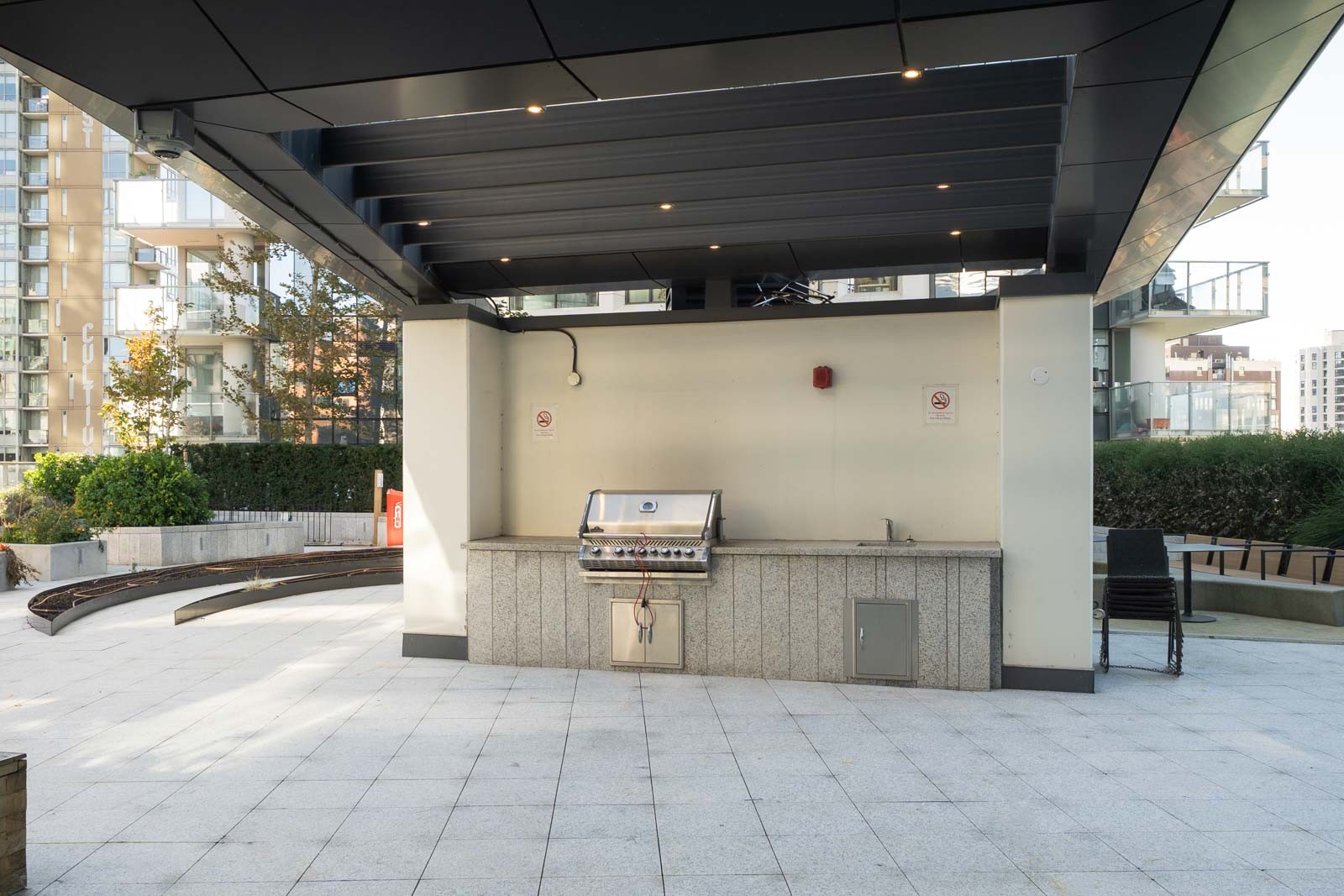 Stainless steel grill, counter, and sink under a covered patio at the 1277 Hornby St office in Vancouver.